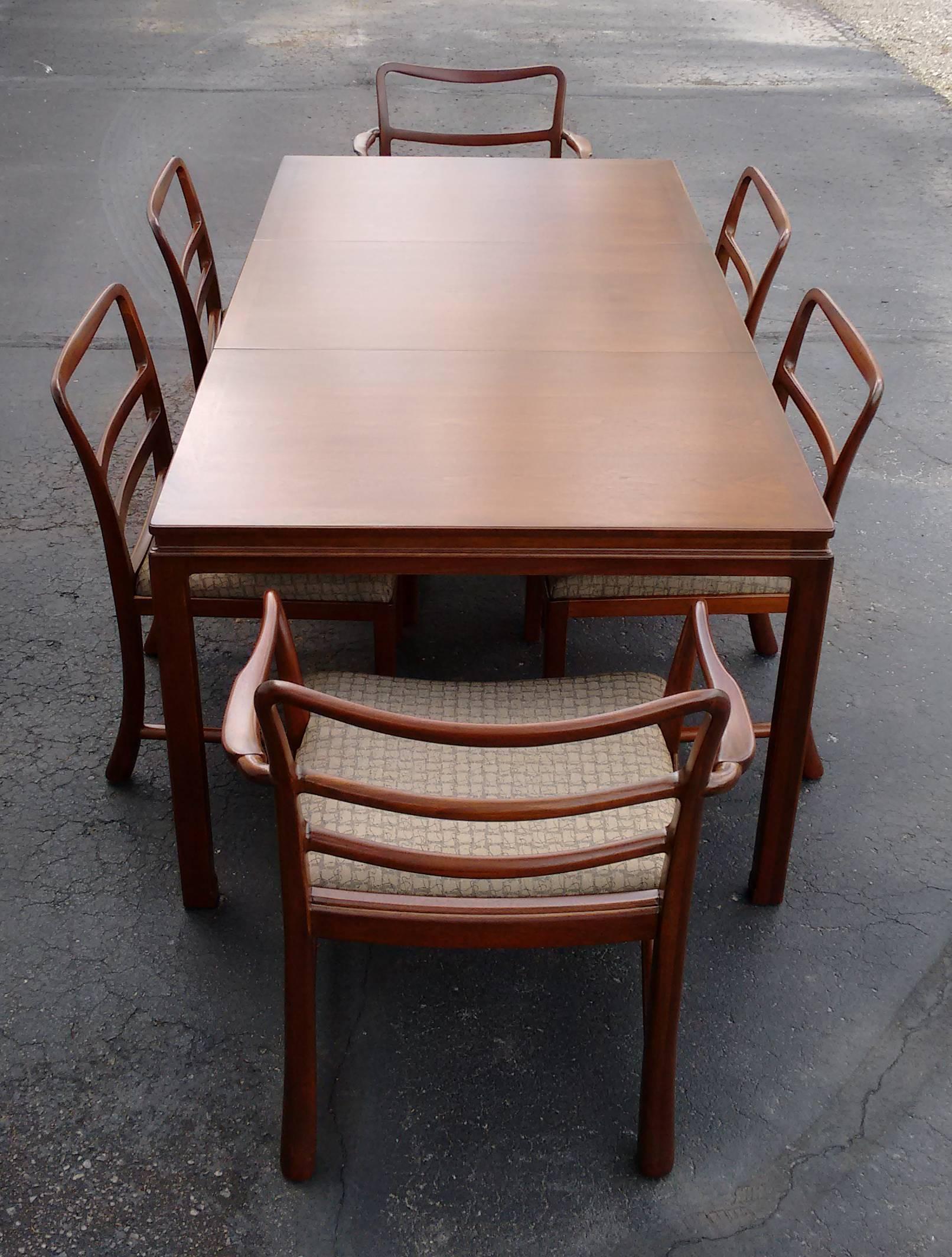 For your consideration is a brown mahogany dining table by Dunbar with six chairs, four side chairs and two with arms and one leaf. In excellent condition. Professionally restored and refinished. The dimensions of the chairs with arms are 33
