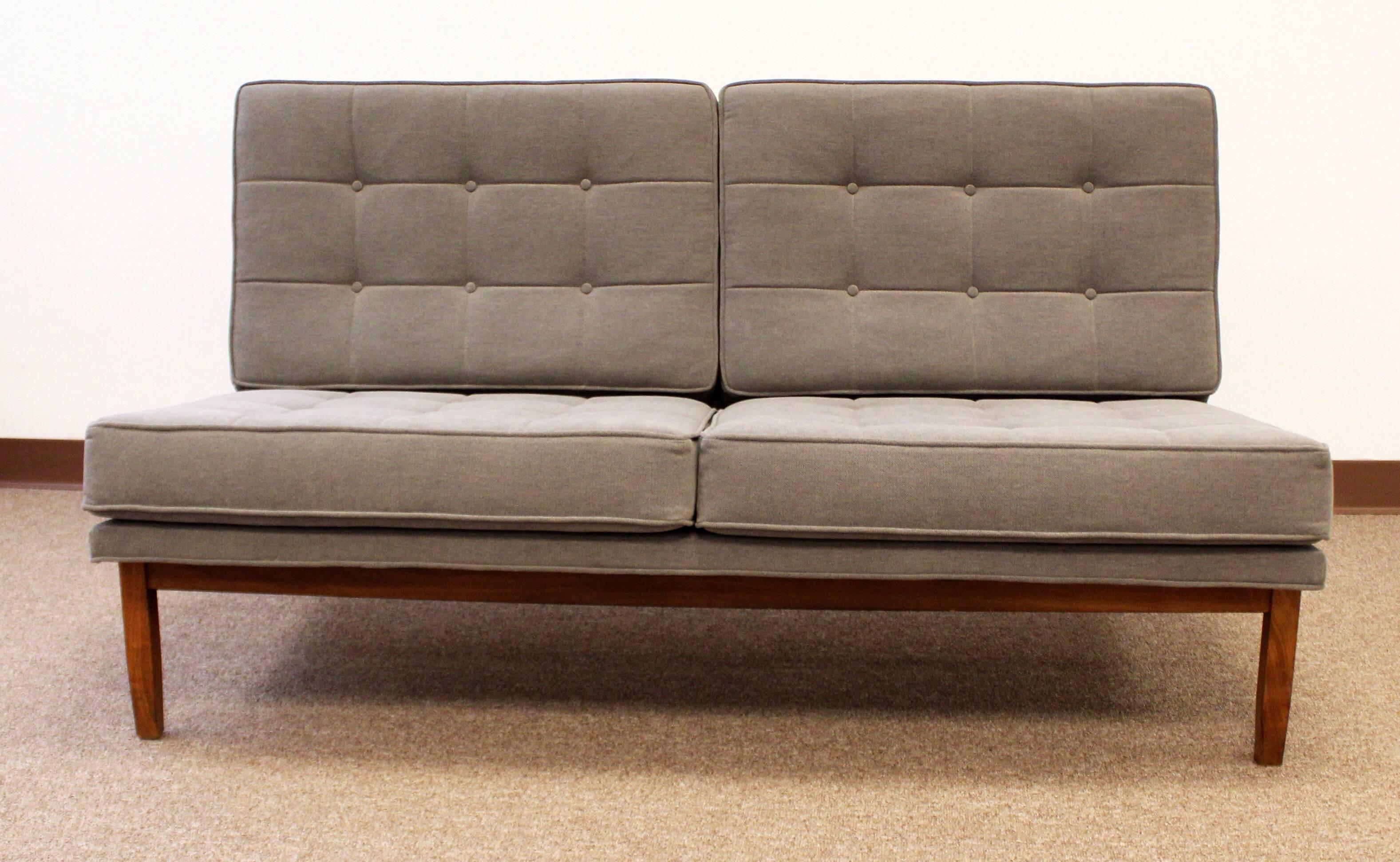 Great seating in this rare Knoll settee and chair. Reupholstered in a gray nuby fabric. Solid walnut frames.