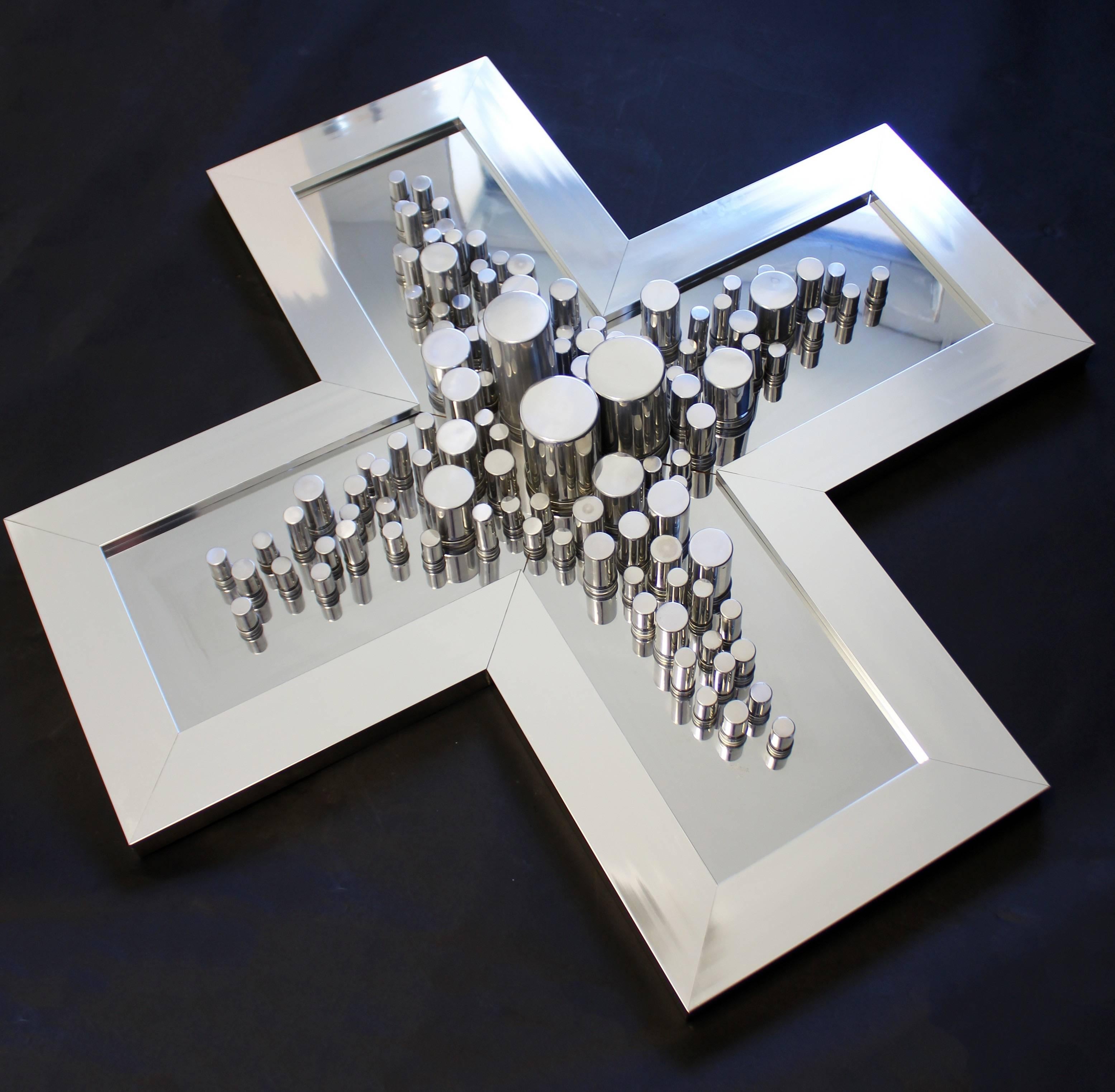 Offered here is an artistic large chrome X-shaped mirror wall art sculpture signed by Greg Copeland, dated 1977. In excellent condition. The dimensions are 40