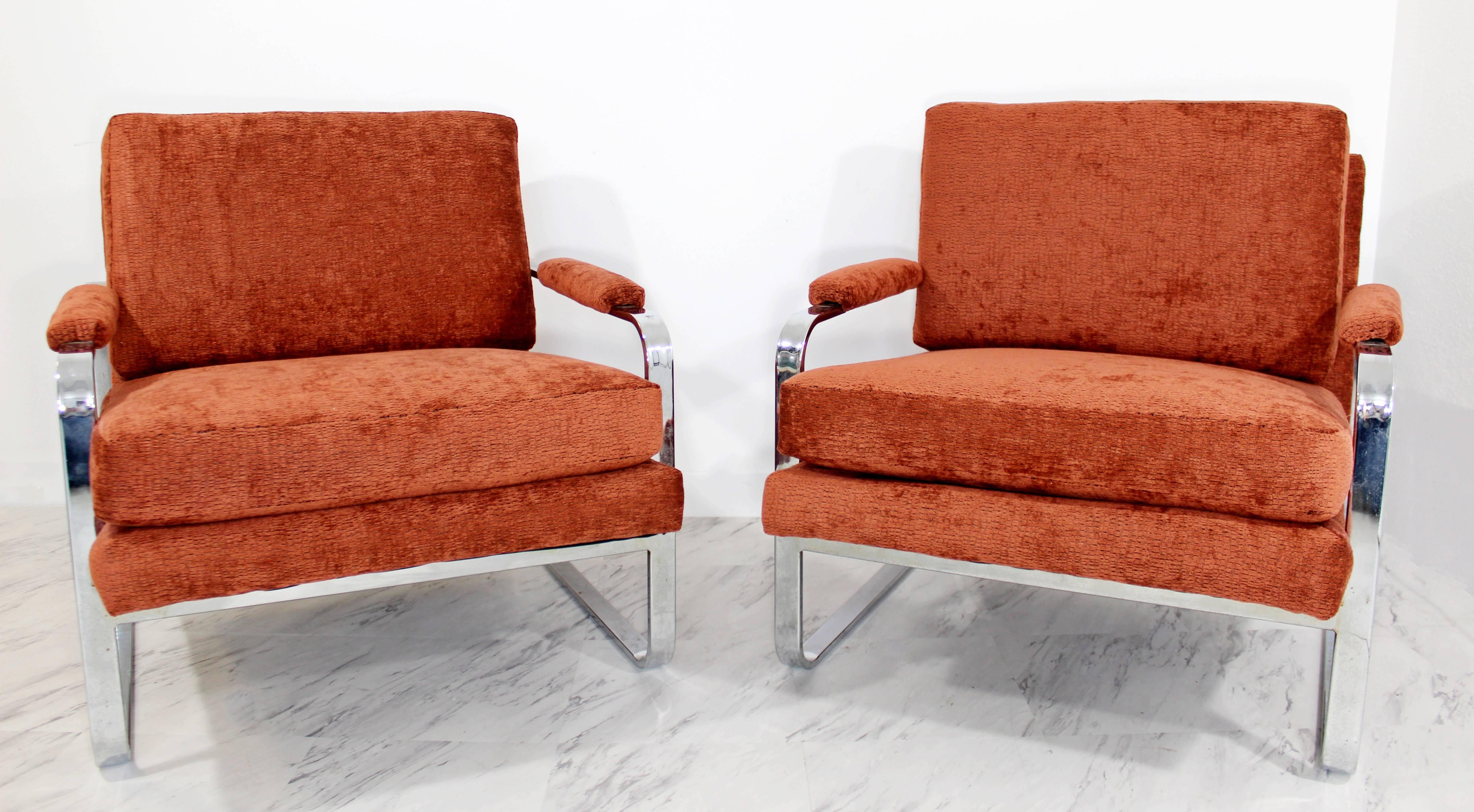 
For your consideration is a fabulous pair of flat bar chrome lounge chairs with a maroon and coral chenille upholstery. Professionally reupholstered and in excellent condition. Chrome is also in excellent condition. The dimensions are 30
