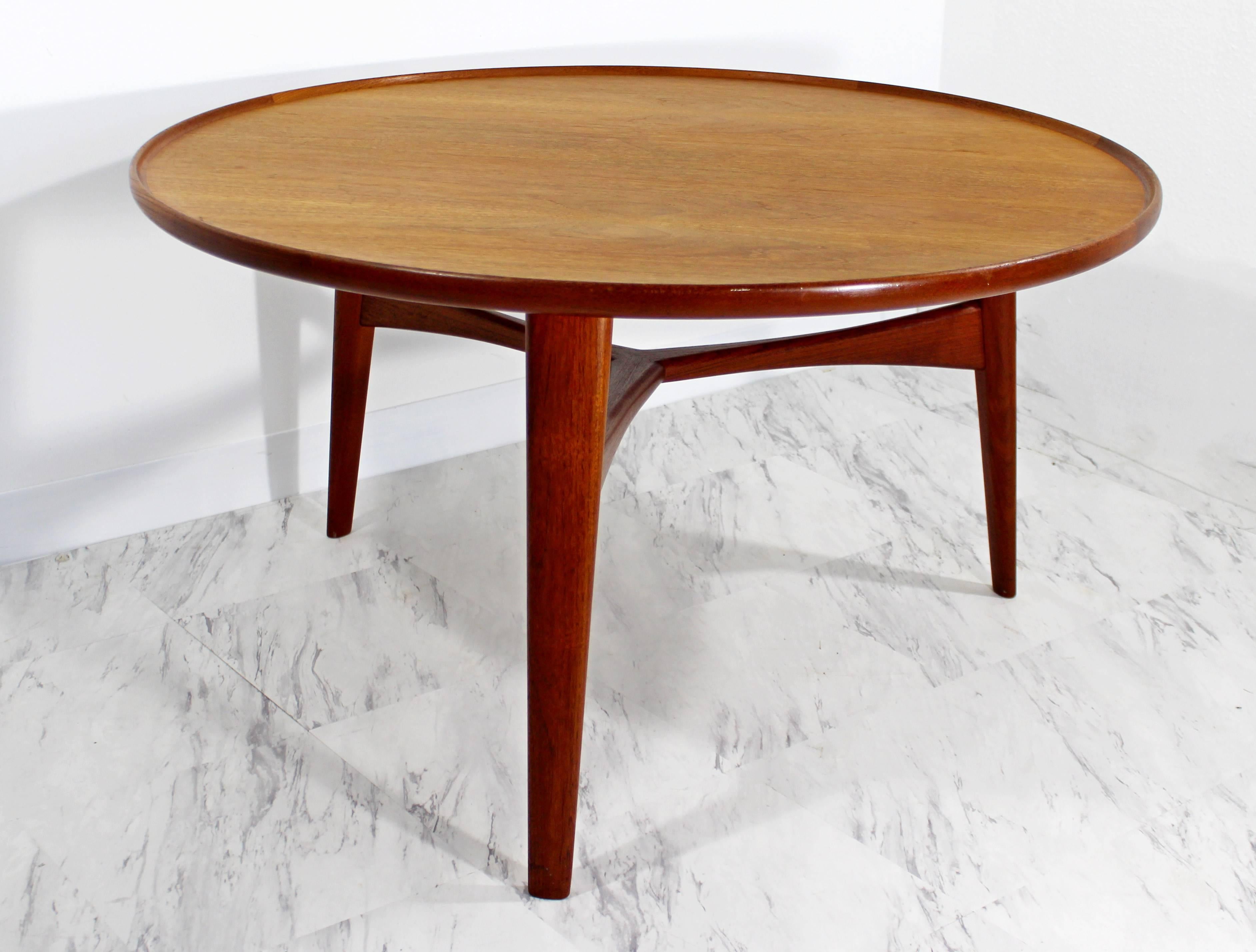 Danish teak circular table with a lipped edge raised on three circular tapered legs joined by a tripartite stretcher. Designed by Aksel Bender Madsen and Ejner Larsen. Produced by Willy Beck, Copenhagen. Original label. In very good condition. The