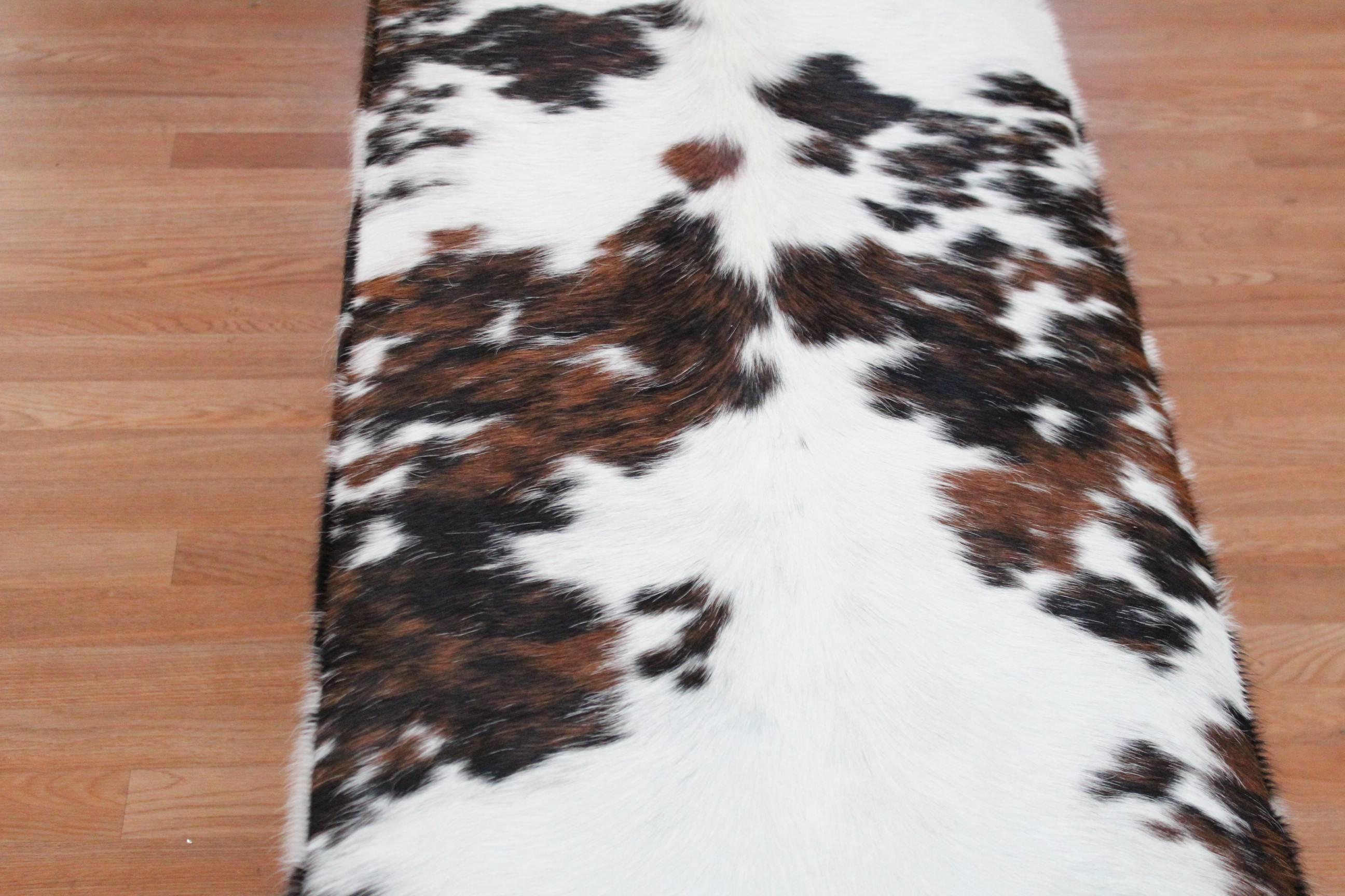 Mid-Century Modern chrome and cowhide upholstered bench, cowhide seat sits atop a chrome band that wraps entirely around the piece.