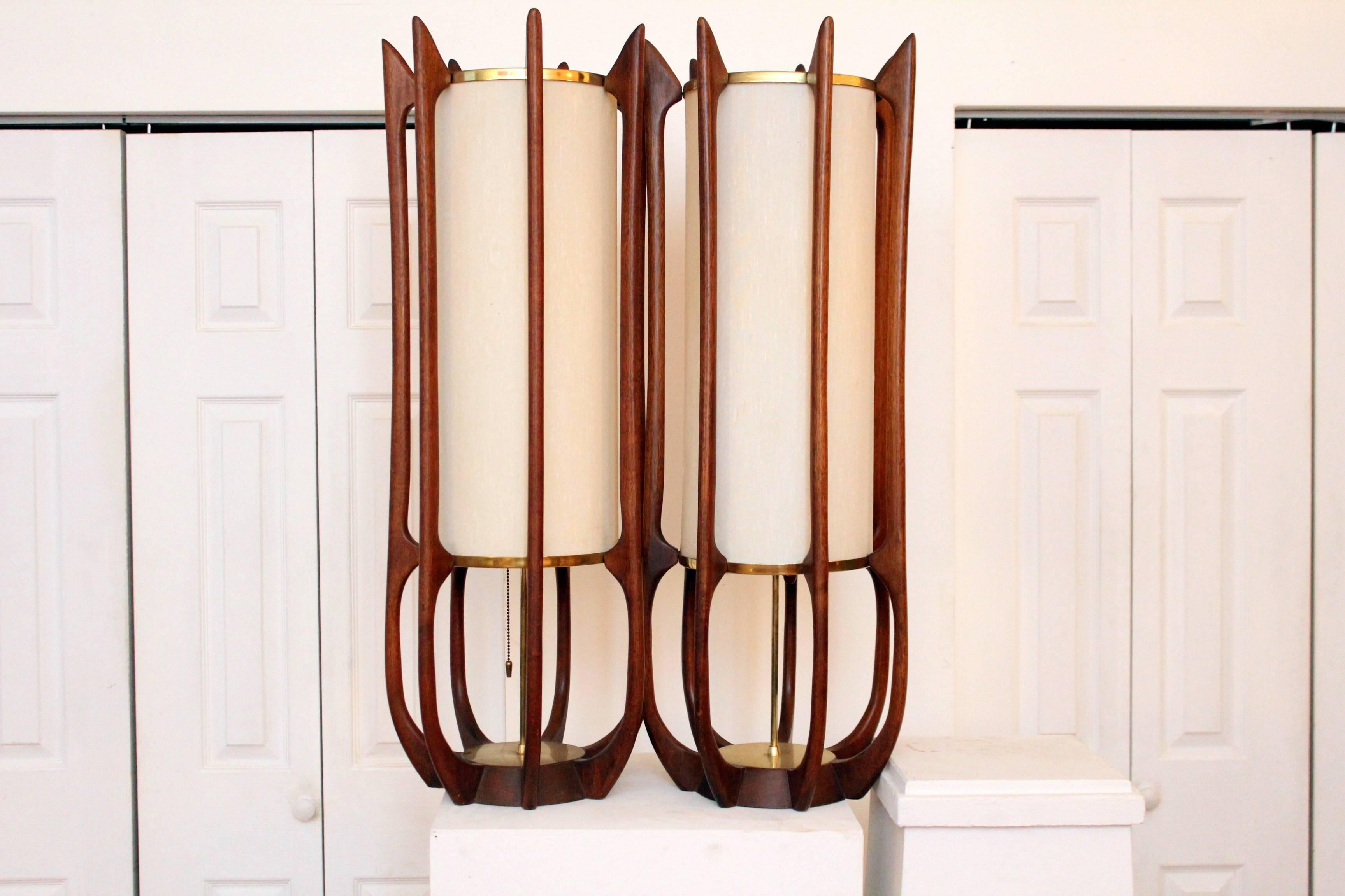Mid-Century Modern Modeline sculptural lamps rarely available, this pair of Modeline table lamps boast tall fiberglass cylinder shades encased in the most beautiful patinated walnut ever. Unadorned circular brass plates add to the quiet beauty of