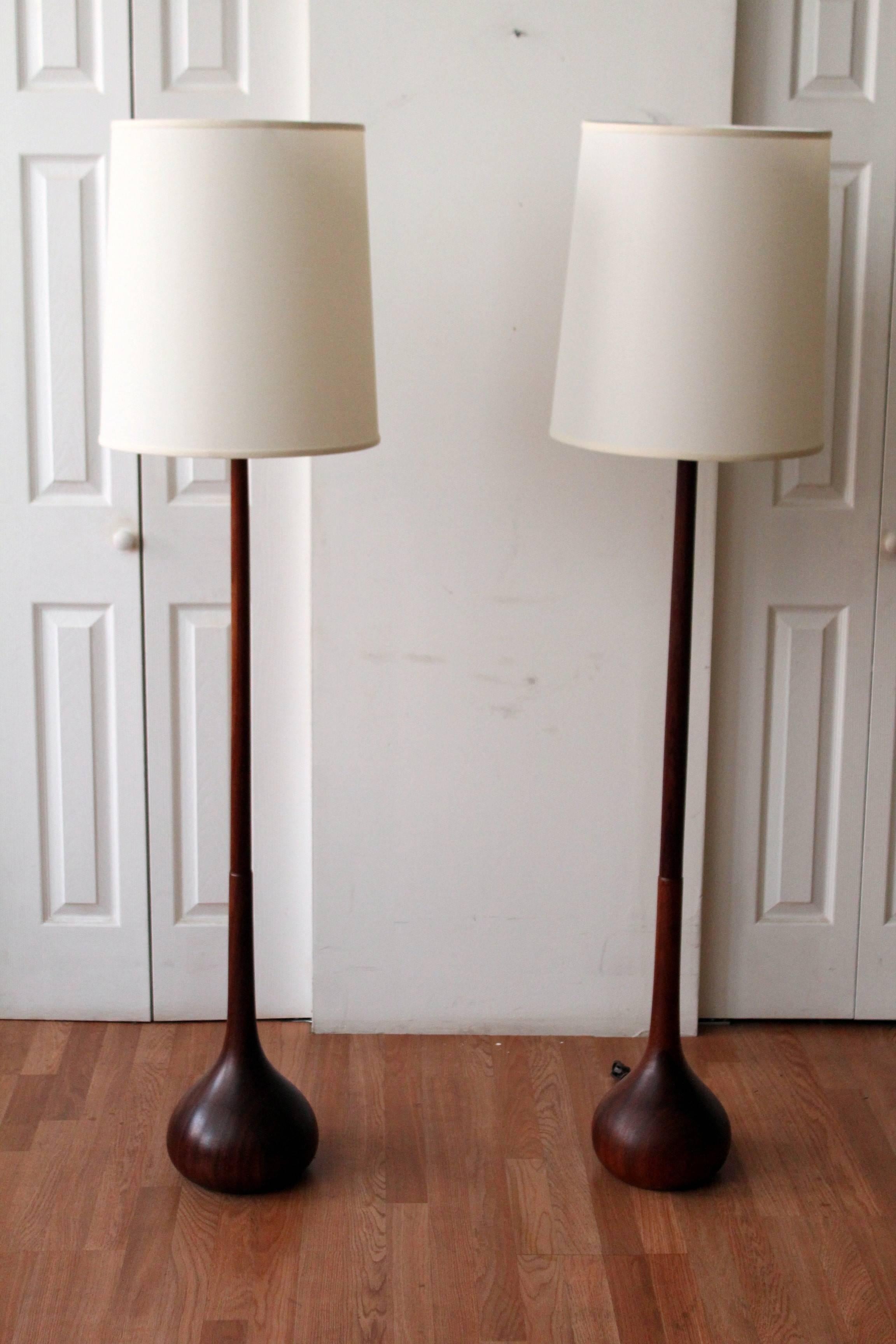 Scandinavian Danish modern walnut floor lamps, with a sculptural bulbous base. This highly sought after works of art come complete with new shade and are ready for immediate installation. 64" from floor to top of lampshade.

*ONE LAMP 