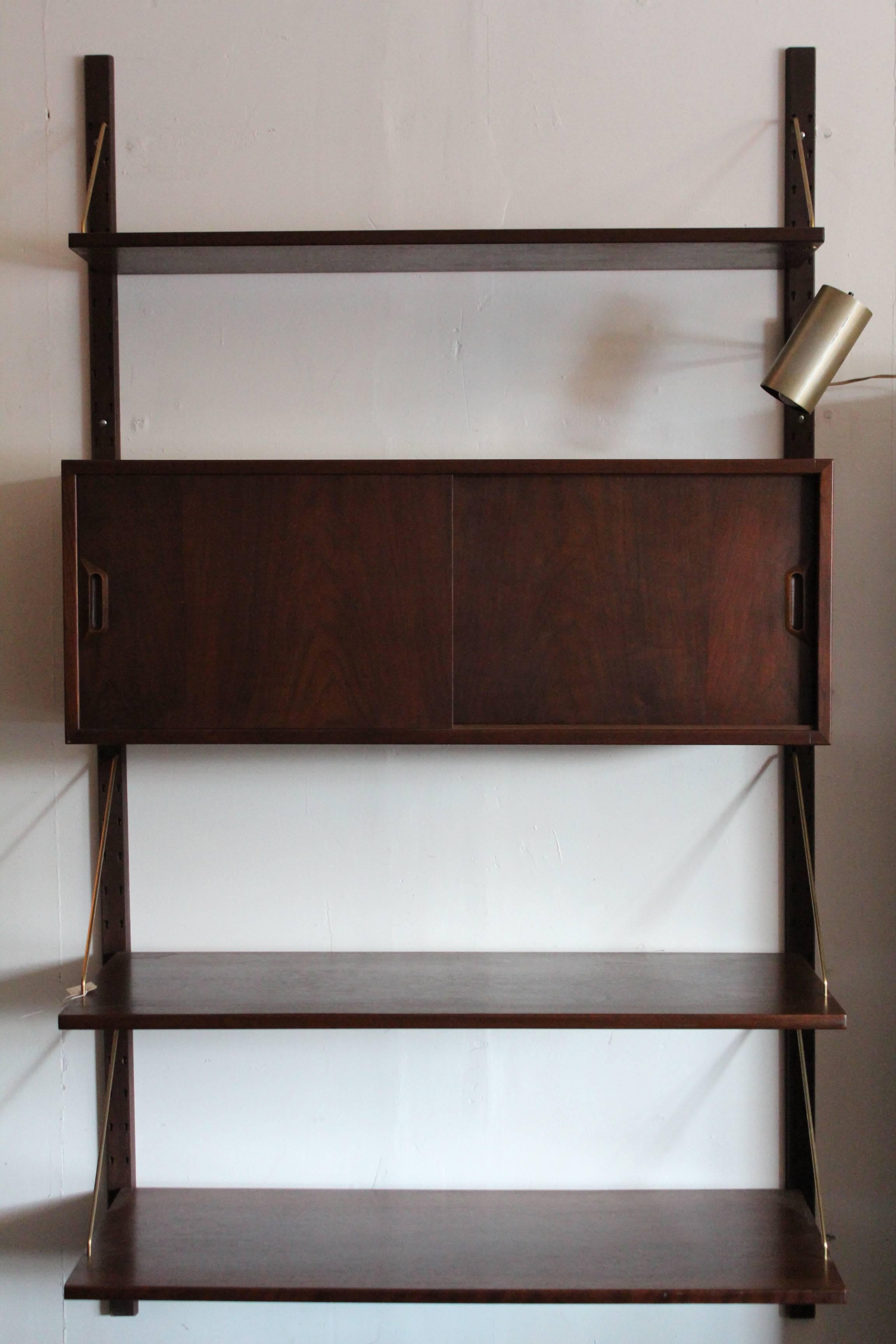 Beautiful warm brass arm details, walnut shelving and a stunning walnut cabinet round out this Sven Ellejkaer for Raymor, Denmark modern floating wall unit. 

Danish walnut 