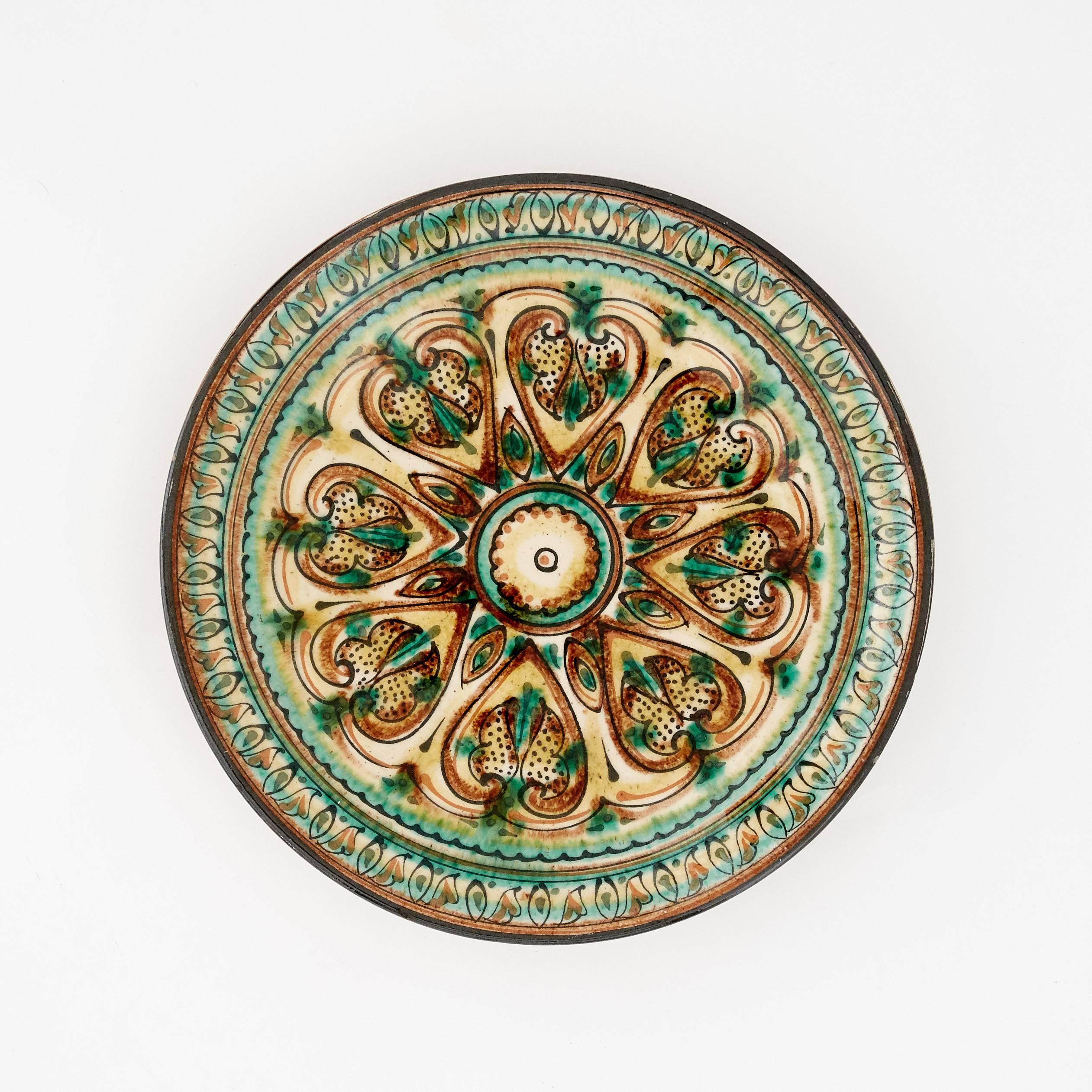 These terracotta serving plates were all handmade in the 20th century. They have a glaze finish and beautiful decorative patterns to embellish them. The three terracotta-color set are from Sweden and have ivory patterns circling the exterior rim of
