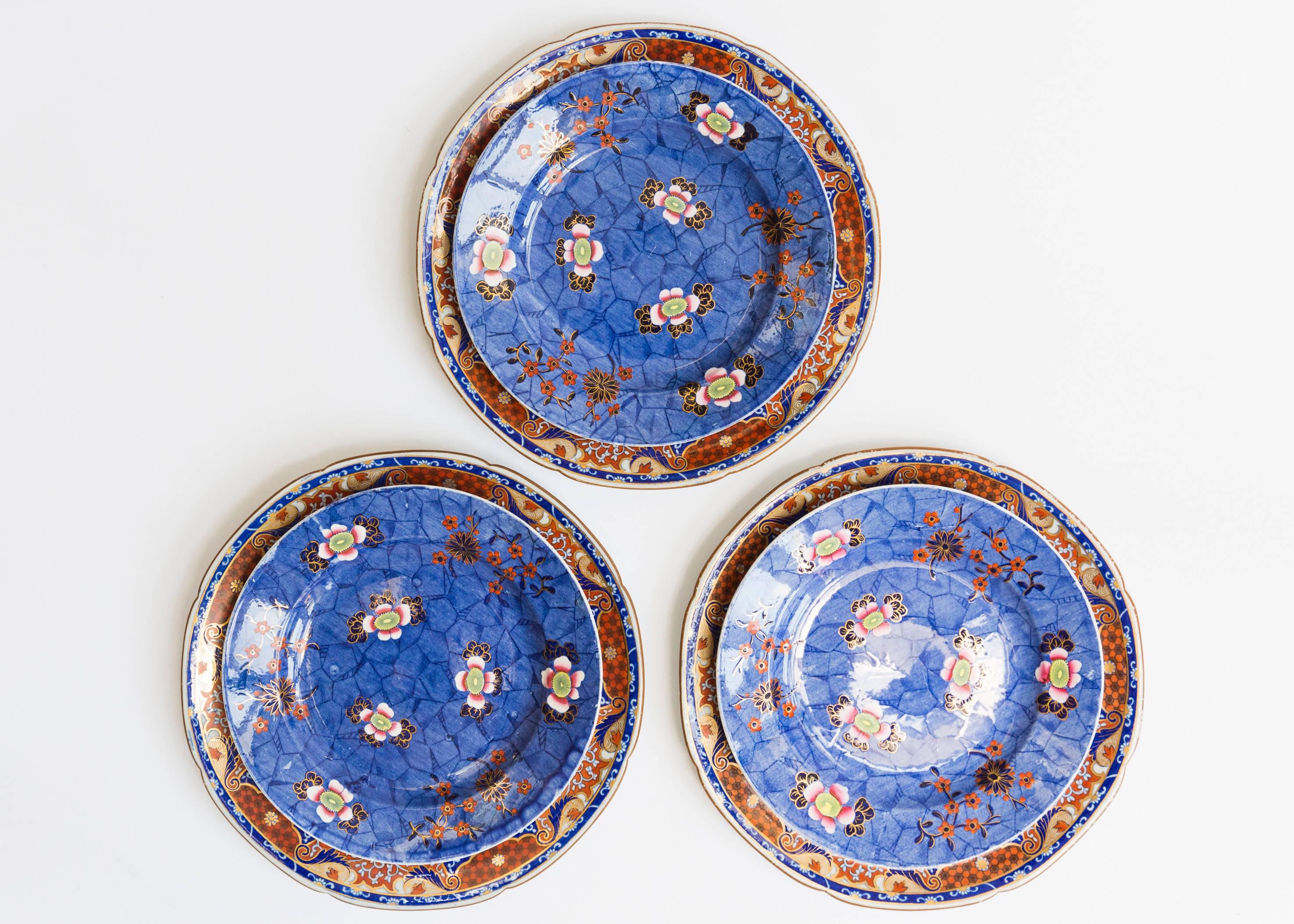 These plates were made in the early 20th century by Spode. The six plates come in two different styles and dimensions. The three larger plates have a white ceramic base and are intricately painted with ornate blue, red and gold painterly motifs. The