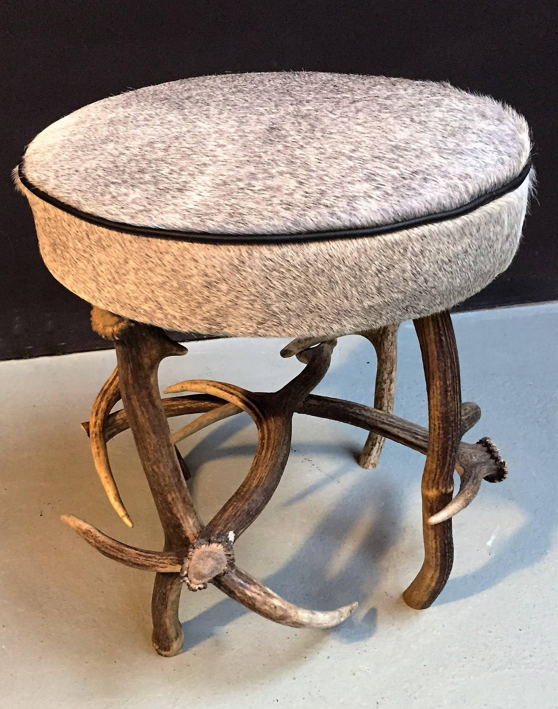 Antler stool made of red deer antlers with an exclusive grey Ecuadorian cowhide. Trimmed with black lining.
 