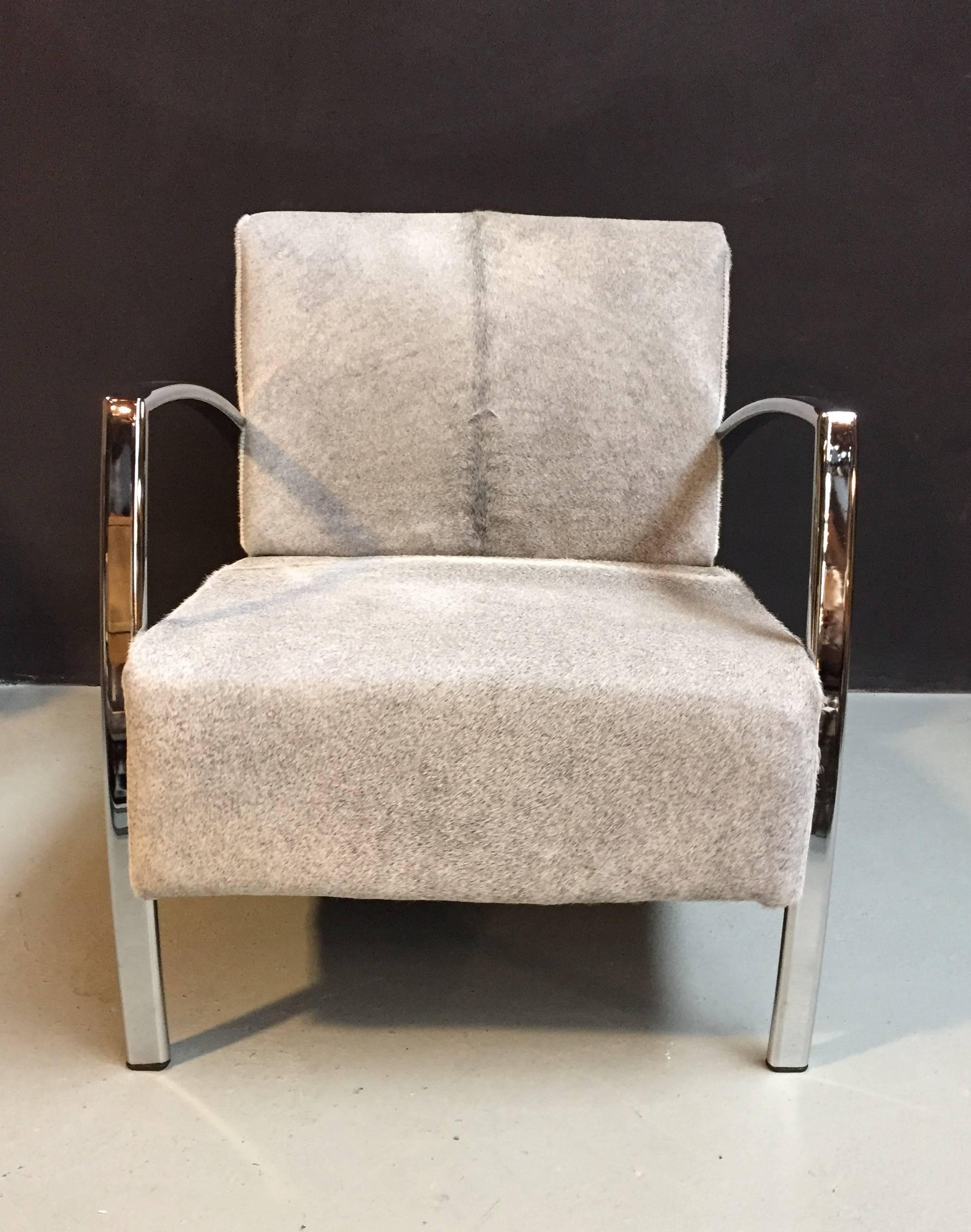 This chair has a grey cowhide upholstery with chromed arm rests and legs.
