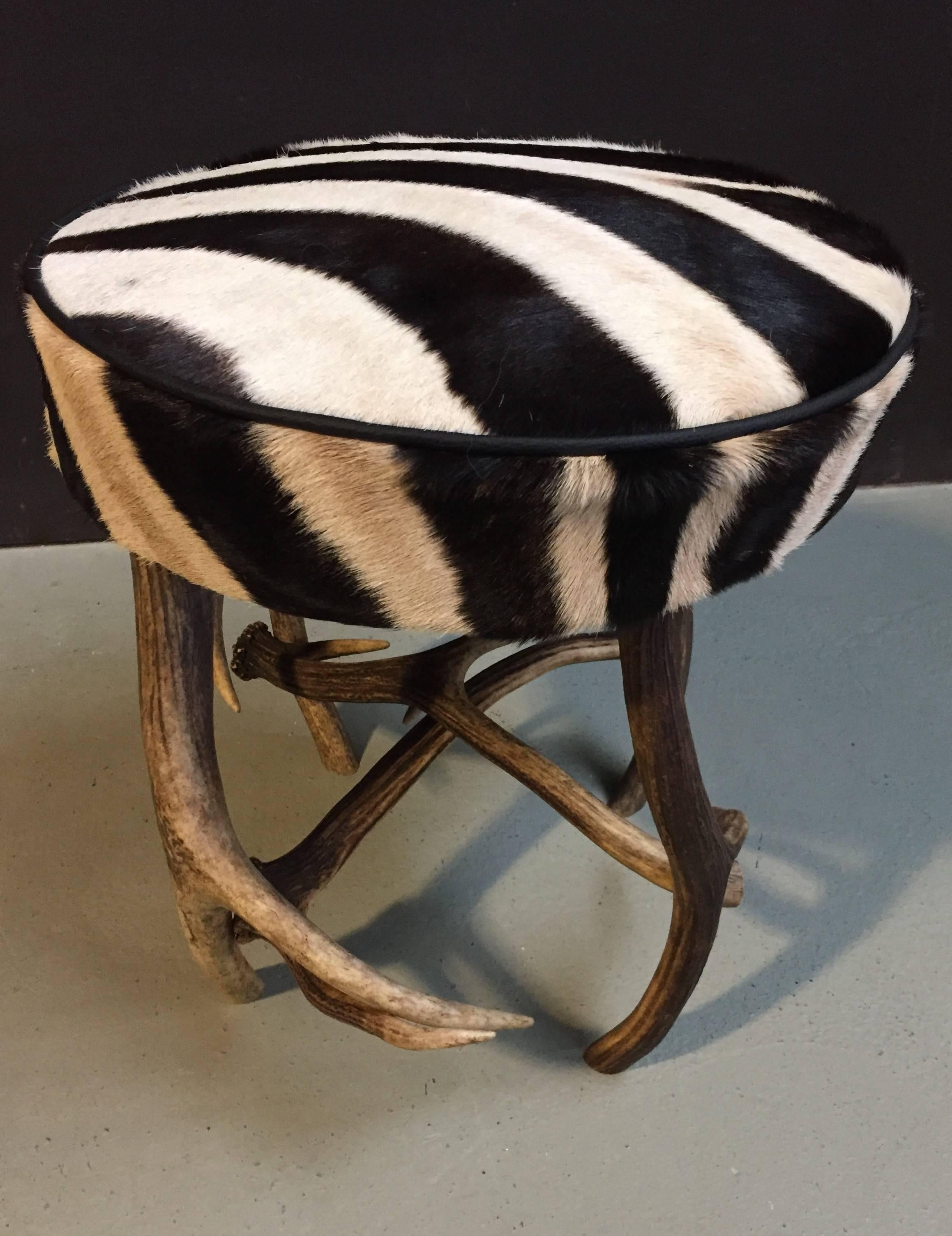 Antler stool made of red deer antlers with a zebra skin top.