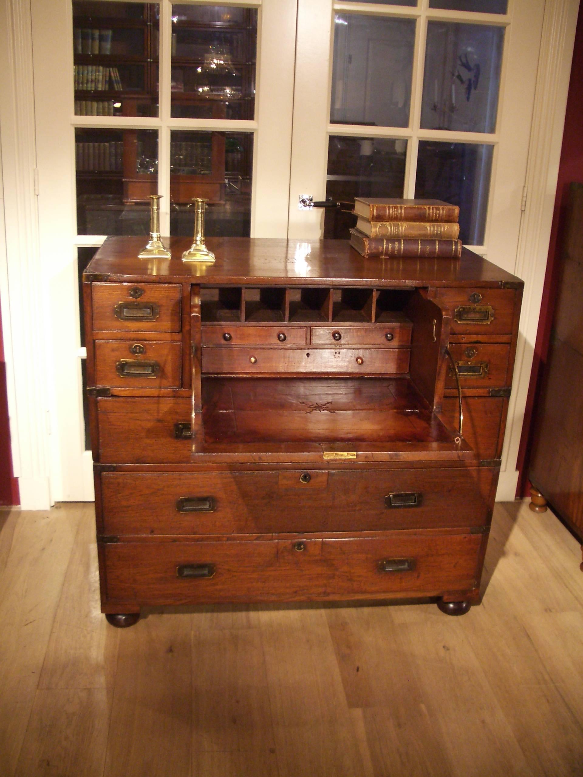 Here is an example of a good quality antique colonial Anglo-Indian military Campaign teak two-part chest of drawers with secretaire.
Chests that were constructed in the colonies, such as this one, were usually constructed of solid teak. This