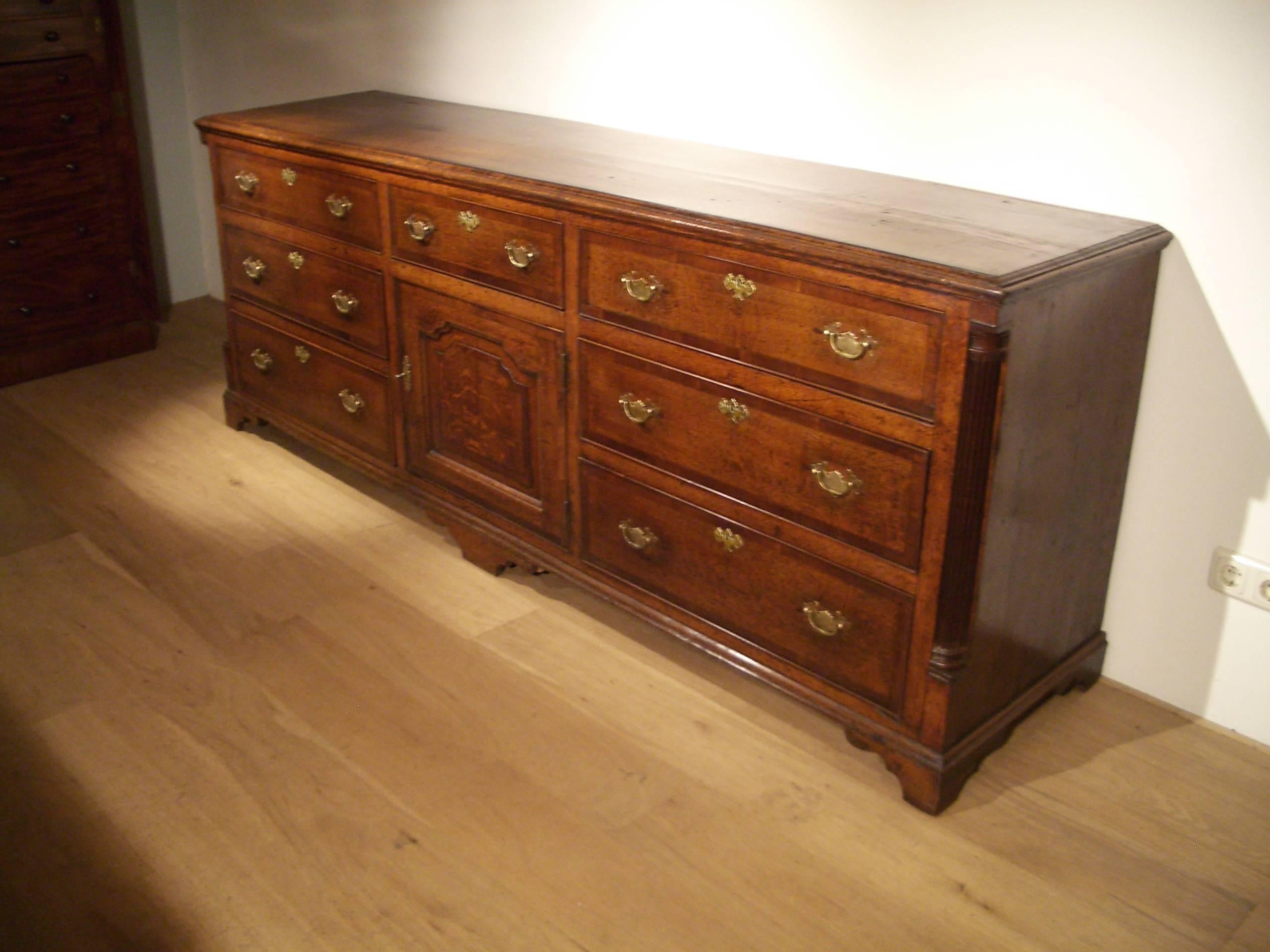 Beautiful and unique 18th century oak dresser. All in perfect and original condition. The drawers, door and top are crossbanded with mahogany. Corners feature fluted pillars this gives a grand appearance. The size of this sideboard is very special.
