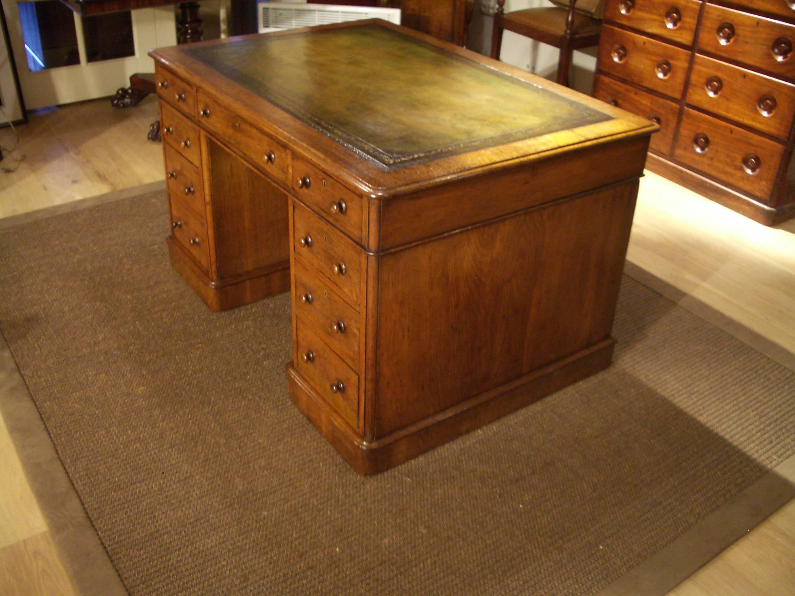 Beautiful antique oak desk in perfect condition. Beautiful weathered oak color. Desk top is with hand-colored green leather with faded gold profiling. It is an early Victorian desk with mahogany lining. The drawers are deep! Desk is finished on all