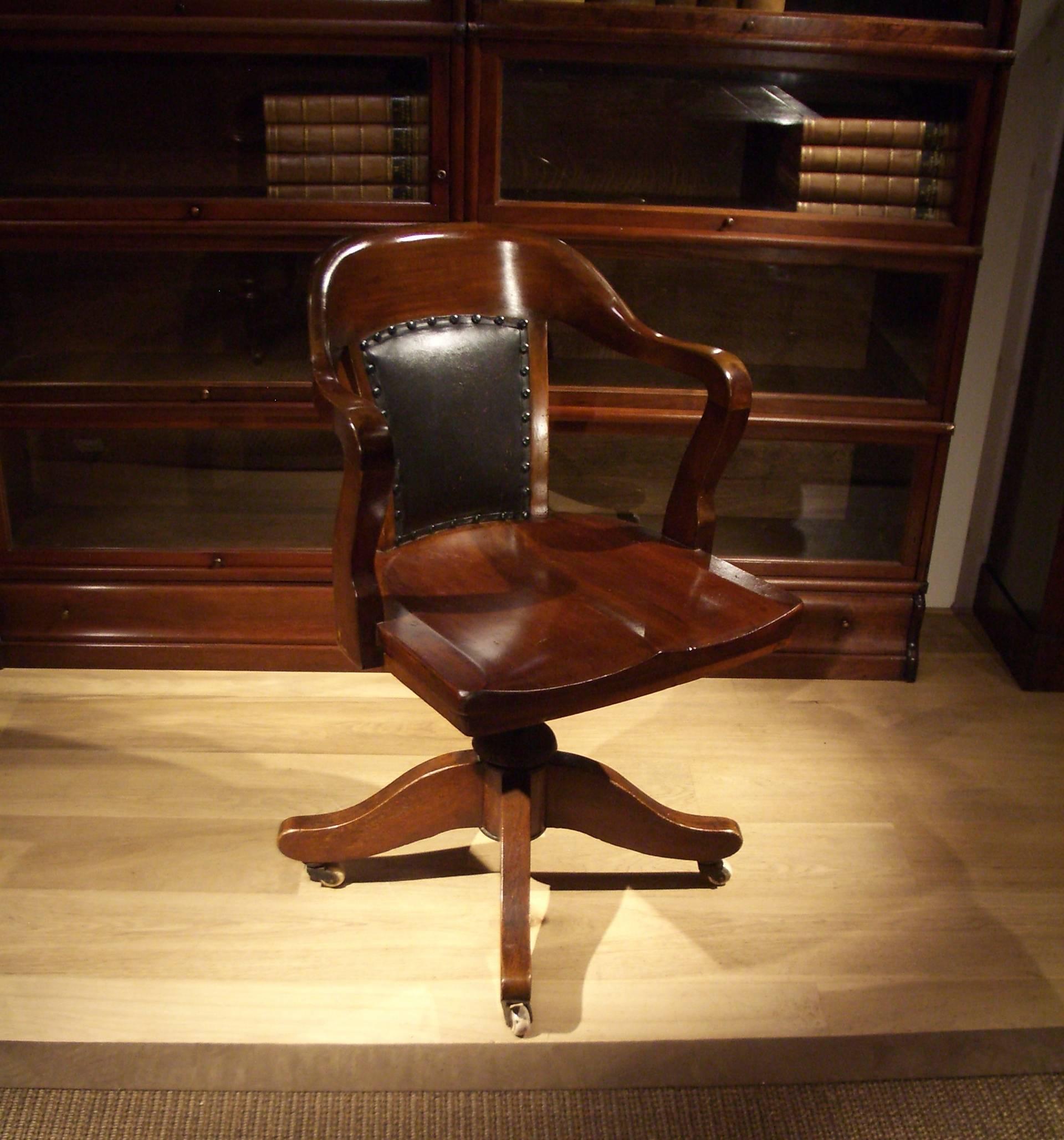Beautiful entirely original mahogany office chair of the Globe Wernicke firm from London. The seat is height adjustable and has a swing mechanism. Chair stands on porcelain wheels. These can be replaced by special wheels for wooden floors. 
Origin: