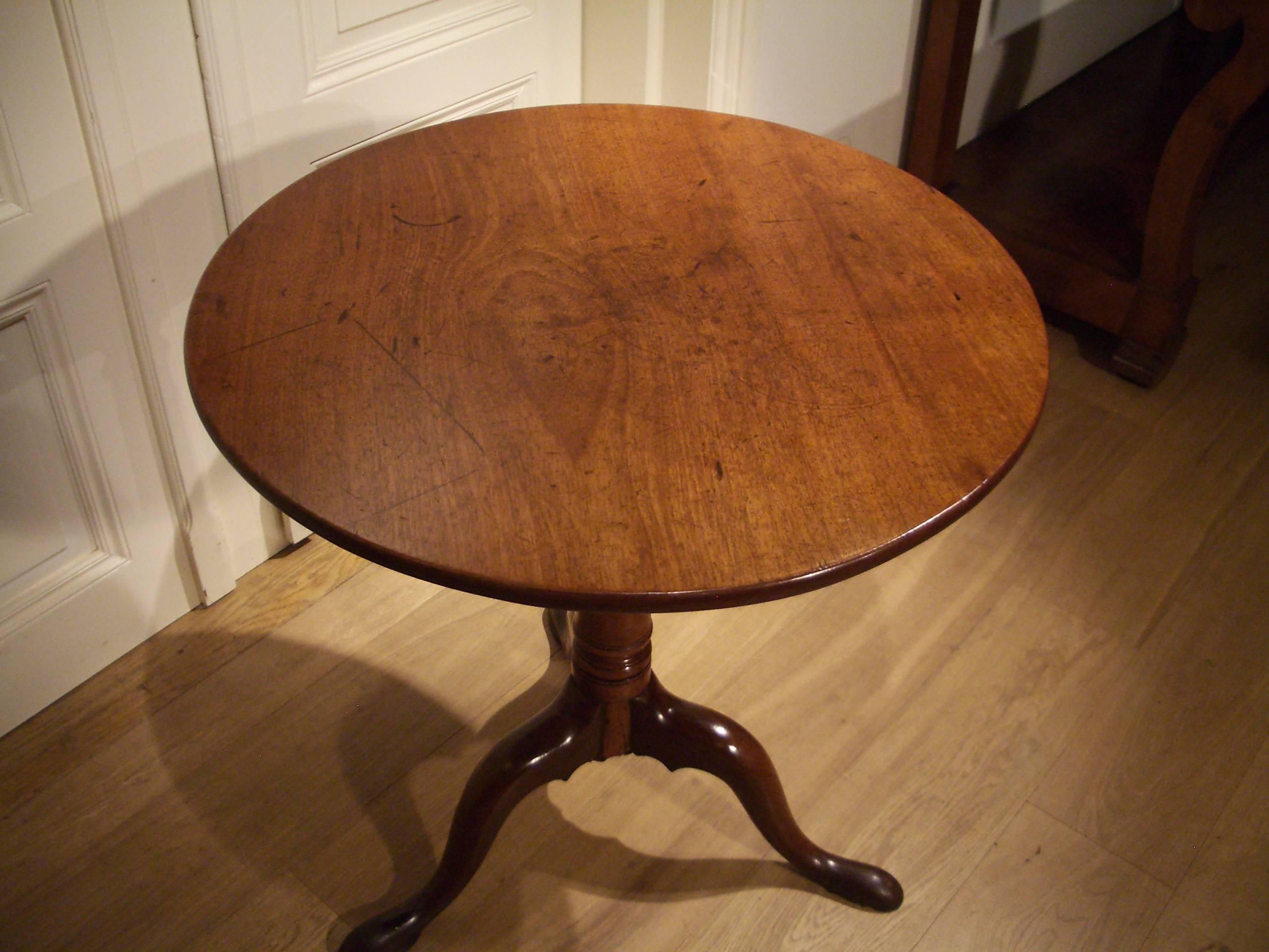 Beautifully aged round tilt-top table made in England. The tilt-top model indicates it can be folded up. A beautiful light mahogany color.