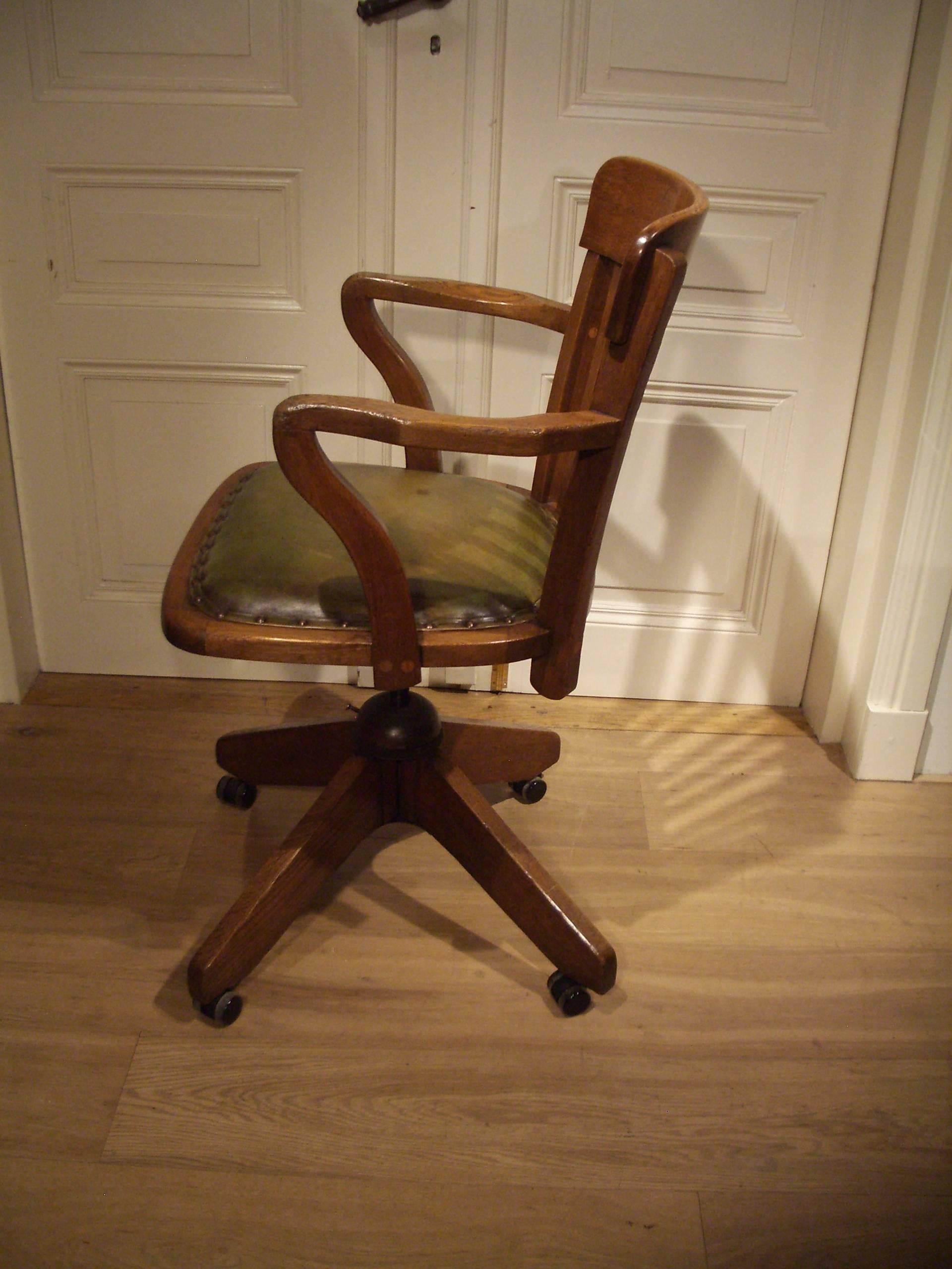 Antique oak office chair in perfect condition. The seat is newly upholstered in green leather. The chair has seat-height adjustment and a rocking mechanism. Equipped with smooth rolling casters, especially for parquet flooring.