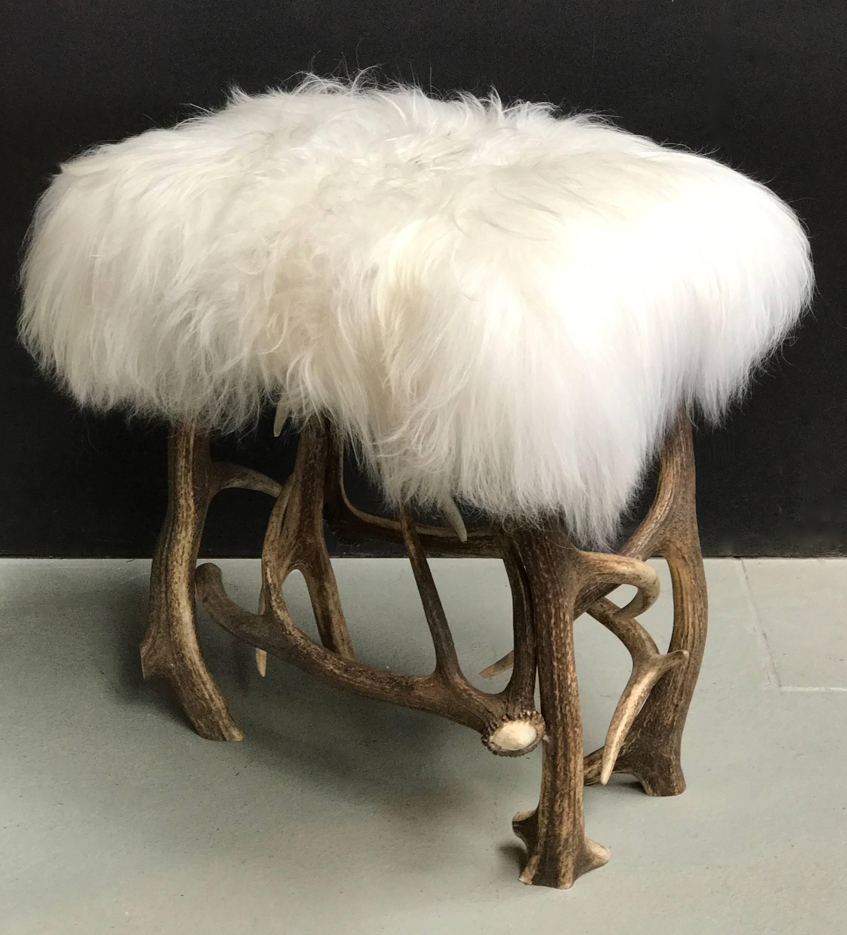 Stool made of red deer antlers upholstered with fluffy snow white Iceland sheep skin.