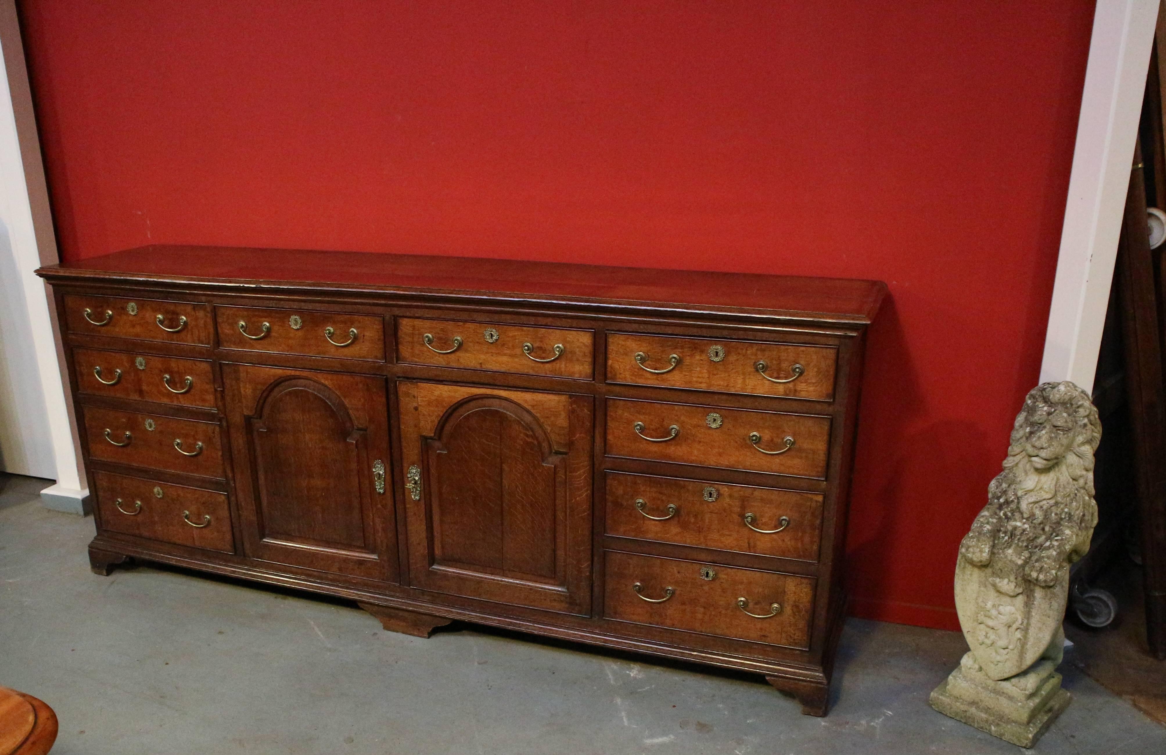 Beautiful and unique 18th century oak dresser. Impressively large antique English oak sideboard. Beautiful warm color and lived-through look. Equipped with ten drawers and two doors. There are also two drawers behind the doors. You hardly ever see