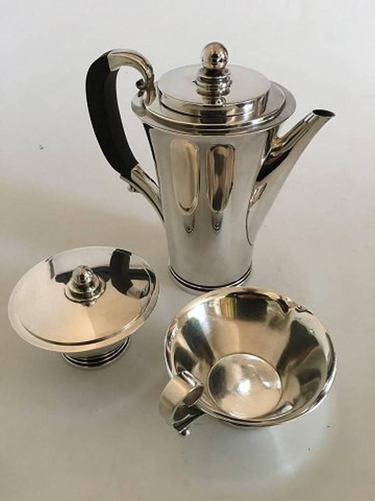 Georg Jensen pyramid sterling silver coffee set no. 600 B. Designed by Harald Nielsen. All the pieces with Georg Jensen marks from 1932-1944.

Coffee pot with wood handle No. 600 B. 20 cm H (7 7/8 in.). Weighs 907 grams.
Sugar bowl with lid no.