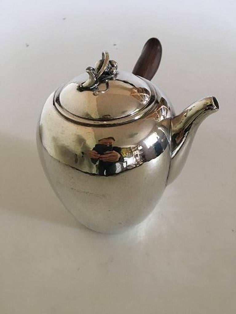 Georg Jensen sterling silver coffee pot no. 875 with wooden handle. By Harald Nielsen. From 1943 marked Georg Jensen & Wendel. Measures: 14.5 cm H (5 45/64in.). Weighs 505 grams.