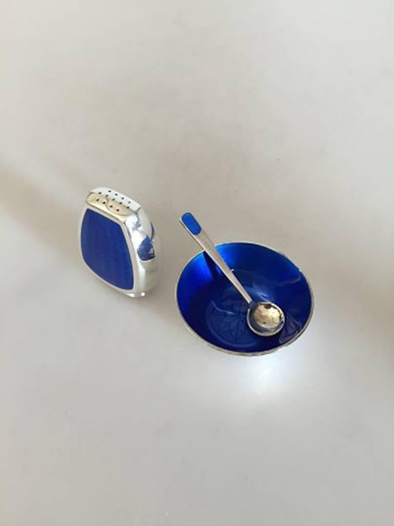 Anton Michelsen salt and pepper set in sterling silver with blue enamel. The pepper shakser's height is 5 cm (1 31/32 in.). Diameter of the salt bowl measures 5 cm (1 31/32 in). Combined weight is 48 g (1,70 oz). In good condition.