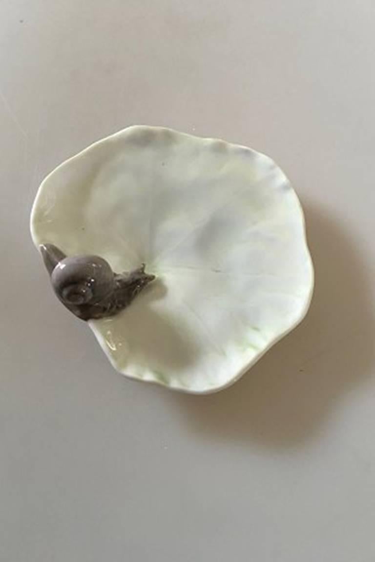 Royal Copenhagen leaf shaped dish with snail #6/3. 

Measures: 10.5 cm D, (4 9/64 in) 3.3 cm, H (1 19/64 in).