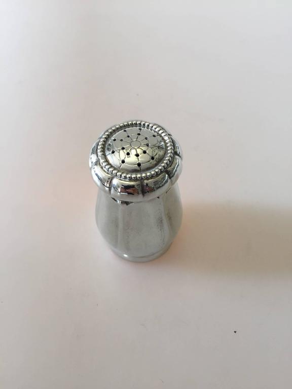 Georg Jensen sterling silver pepper shaker. 

Place of origin: Denmark, 1915-1920. 

Georg Jensen (1866-1935) opened his small silver atelier in Copenhagen, Denmark in 1904. By 1935 the year of his death, he had received world acclaim and was
