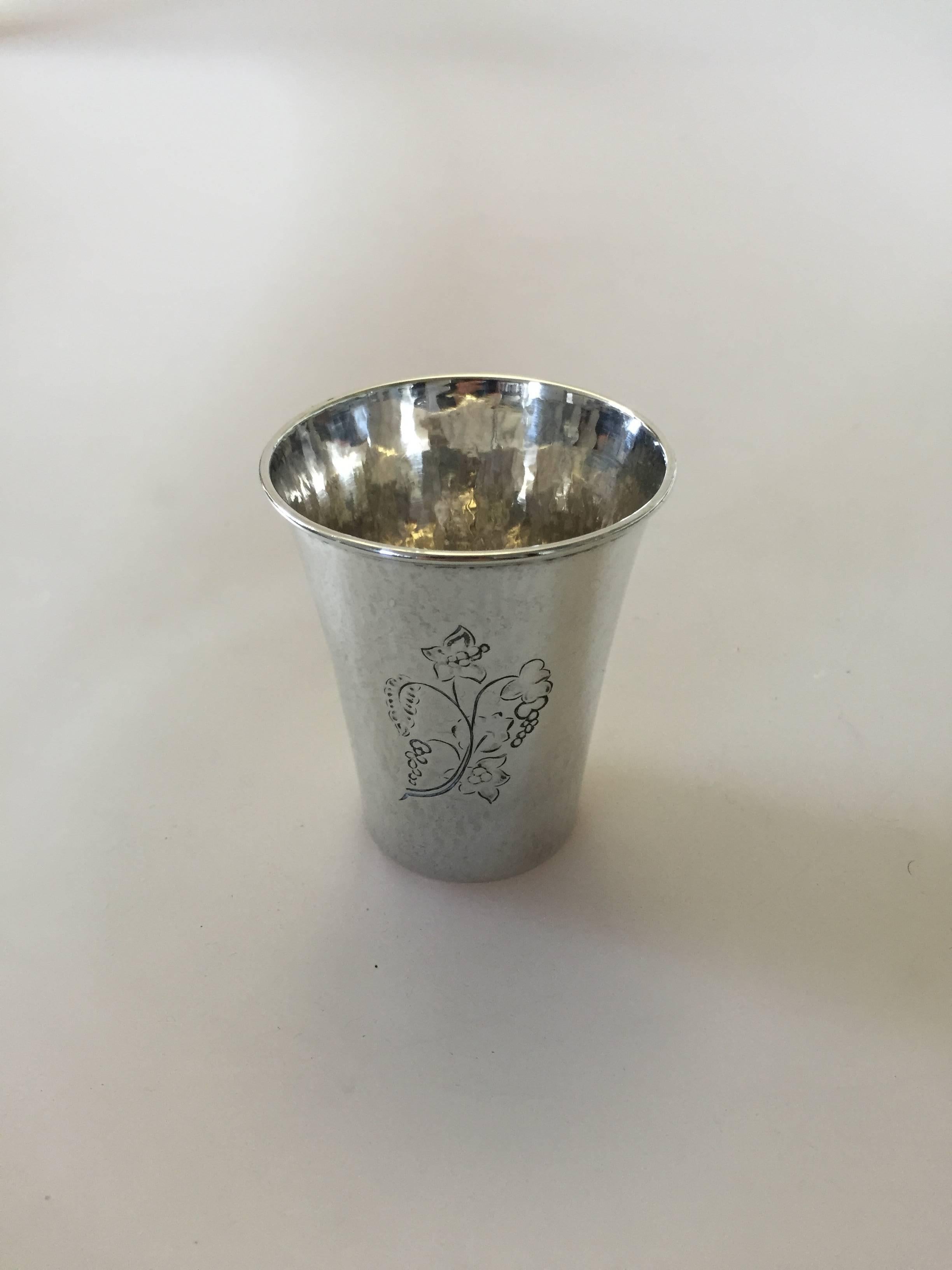 Georg Jensen sterling silver cup. Designed by Georg Jensen and measures 7 cm. The silver cup is engraved, has a few dents but otherwise in a good condition.

Georg Jensen (1866-1935) opened his small silver atelier in Copenhagen, Denmark in 1904.