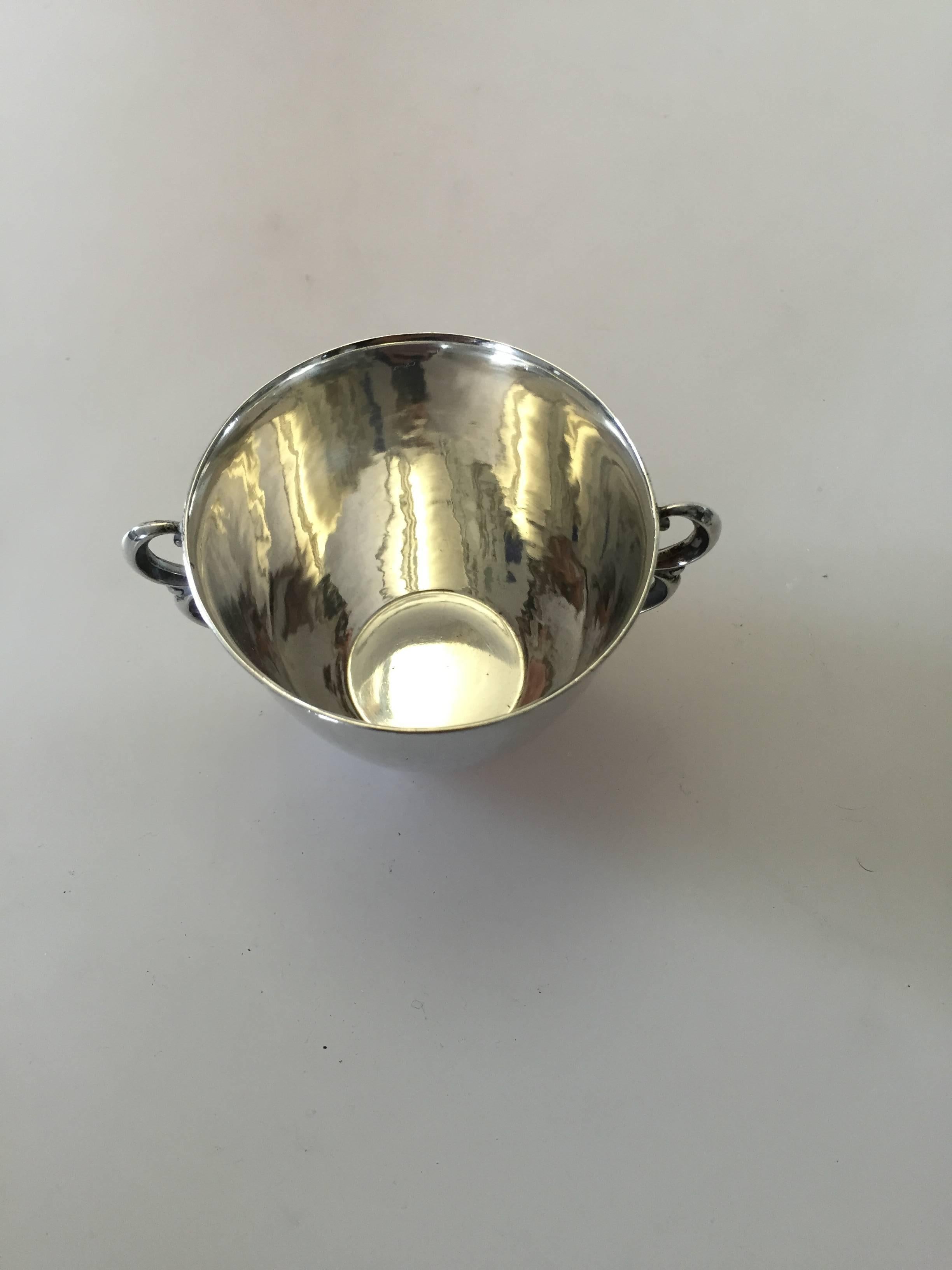 Georg Jensen sterling silver cup with handles #373A. The cup is designed by Georg Jensen. This item has marks from 1945-1951 and is in a good condition. 

Georg Jensen (1866-1935) opened his small silver atelier in Copenhagen, Denmark in 1904. By