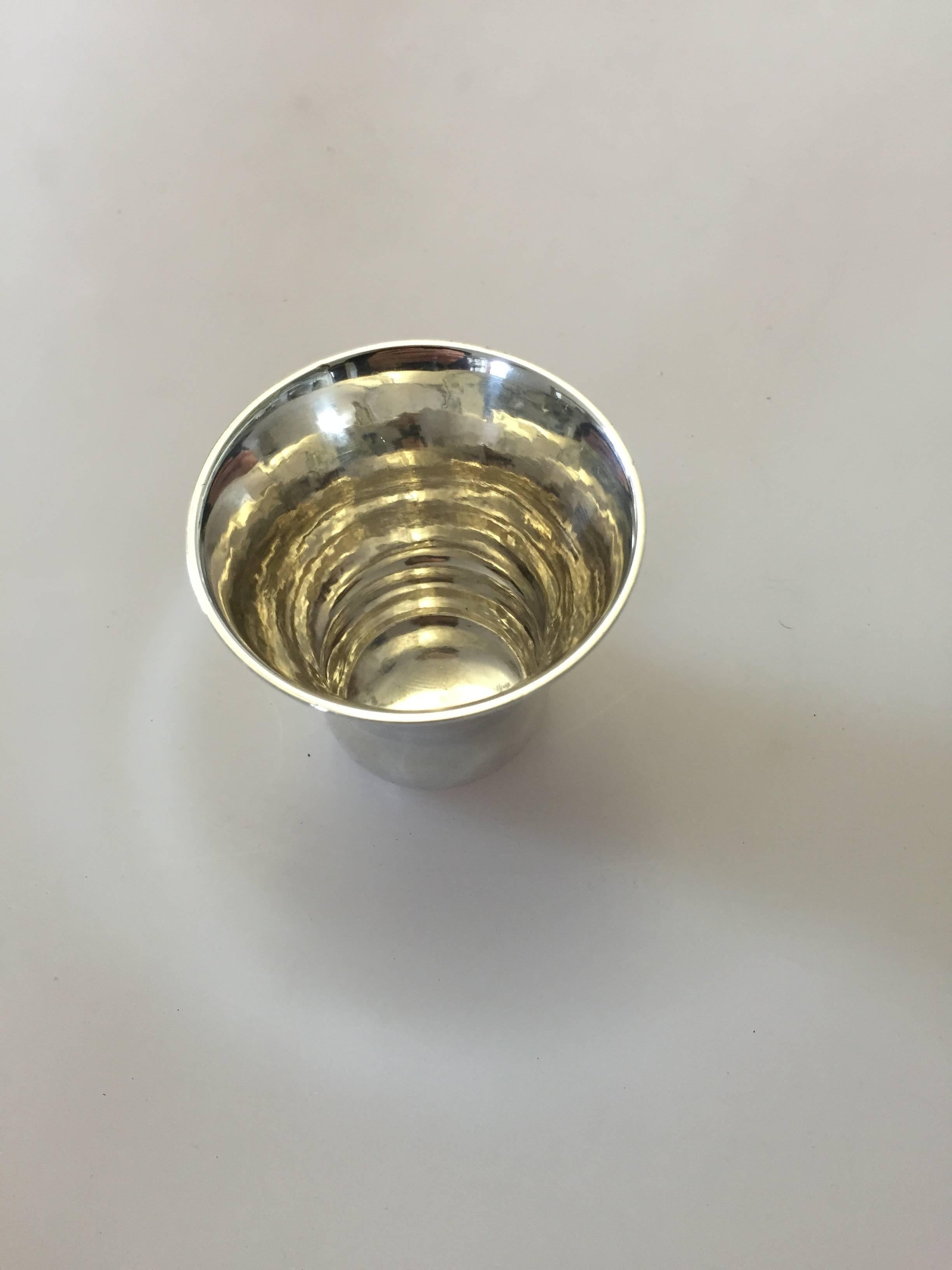 Georg Jensen sterling silver cup #391. Designed by Georg Jensen this cup measures 6 cm. It has a few dents and is engraved but otherwise in good condition. 

Georg Jensen (1866-1935) opened his small silver atelier in Copenhagen, Denmark in 1904.