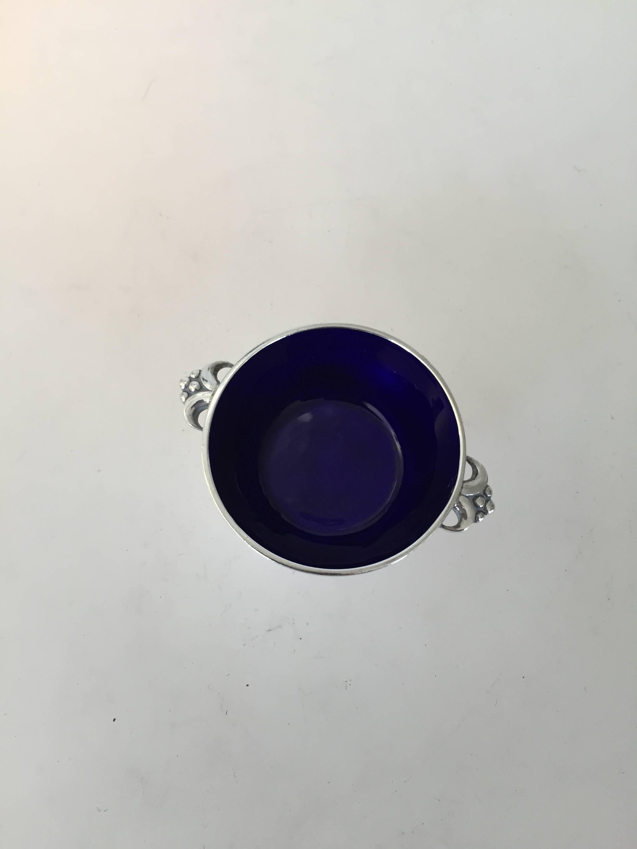 Evald Nielsen sterling silver salt dish with blue enamel. The salt dish measures 5.8 x 1.9cm and is in a good condition. Marked: Sterling Silver, Evald Nielsen, Denmark.

Evald Nielsen (1879-1958) was a Danish silversmithy. Evald Nielsen opened