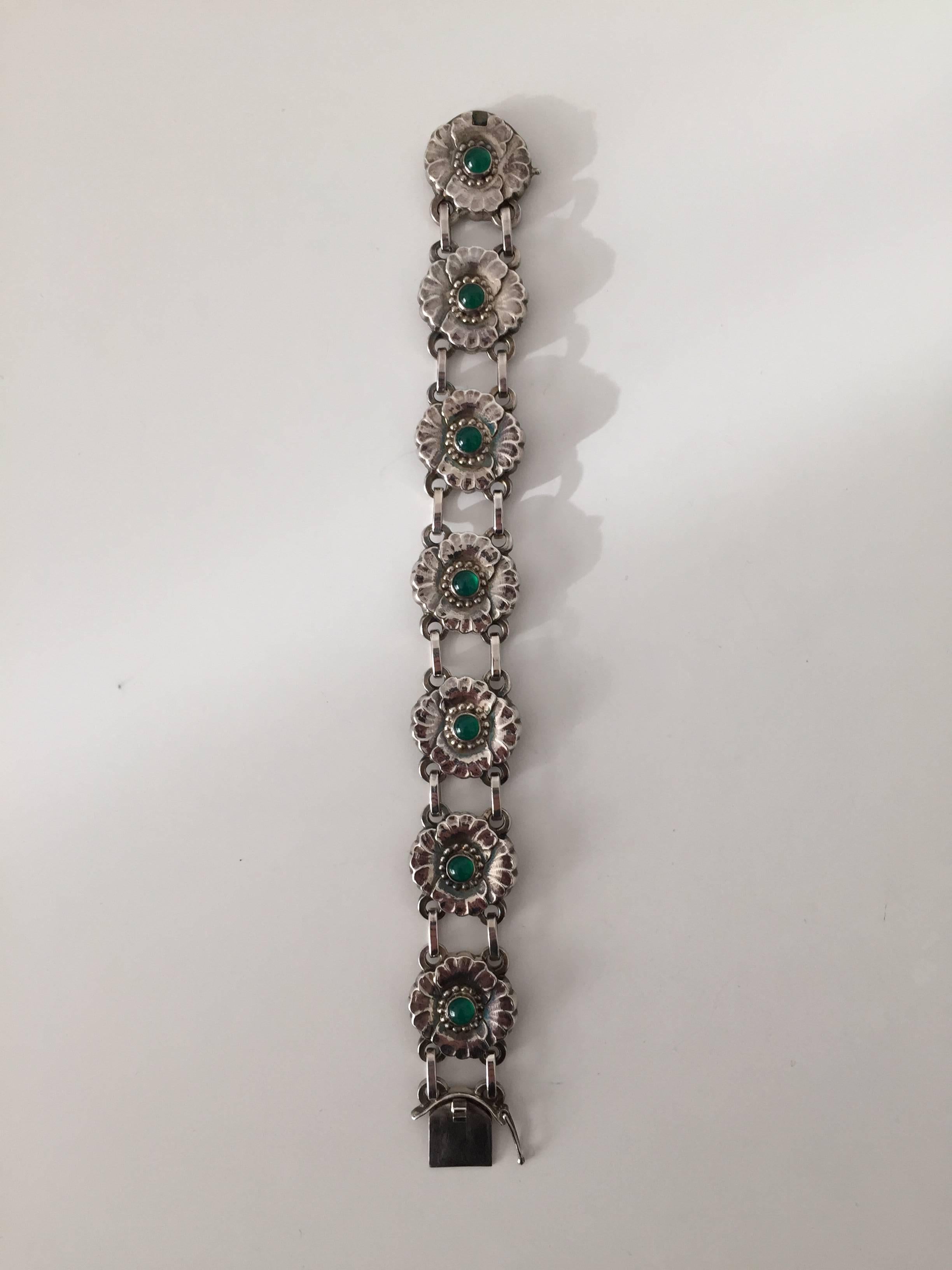 Georg Jensen sterling silver bracelet #36 with green stones. Is in perfect condition.

Measures: 19 cm long. 2 cm wide. 
Weighs 32.8 g / 1.15 oz.