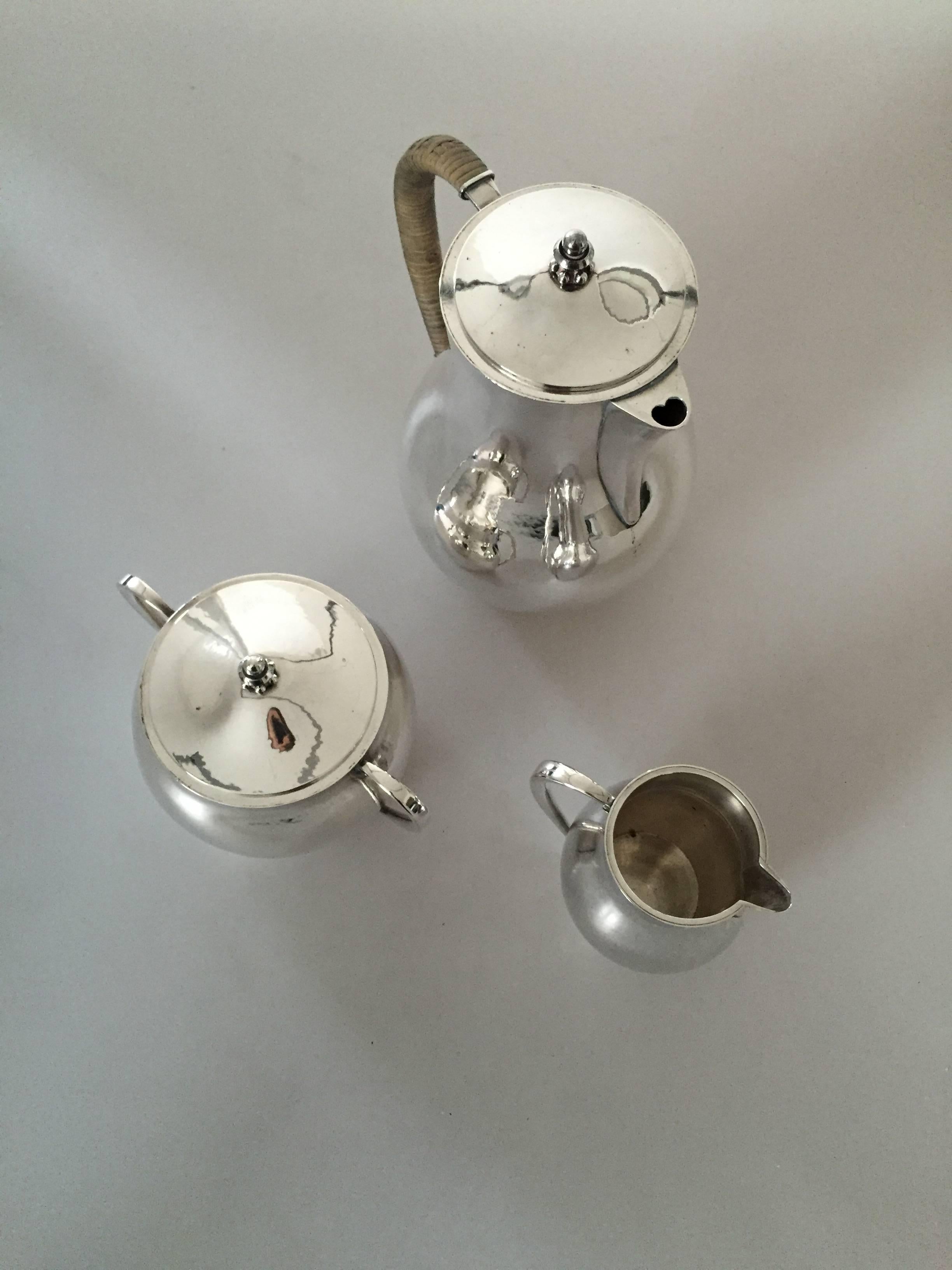 Hans Hansen sterling silver coffee pot, creamer and sugar bowl with cover designed by Karl Gustav Hansen. All pieces are in good condition.

Pot measures 21 cm high. 14 cm in diameter. 
Creamer 10 cm high.
Sugar bowl 15 cm wide, 10.5 cm