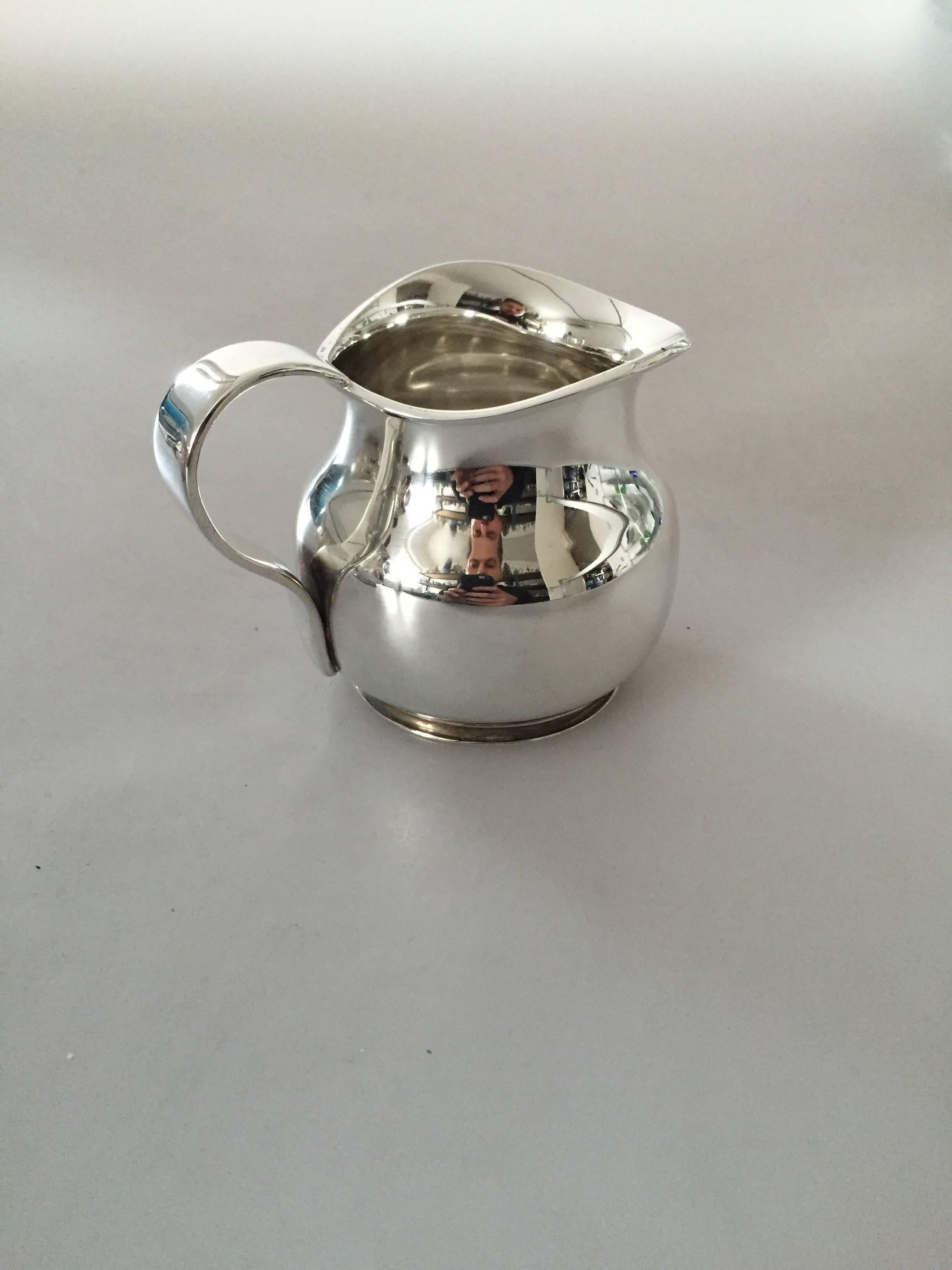 Hingelberg sterling silver coffee set; Coffee Pot, creamer, and sugar bowl. The set is from 1936 and was designed by Svend Weihrauch. All pieces are in good condition.

Coffee pot measures 21.5 cm tall, lid opening measures 9.5 cm in