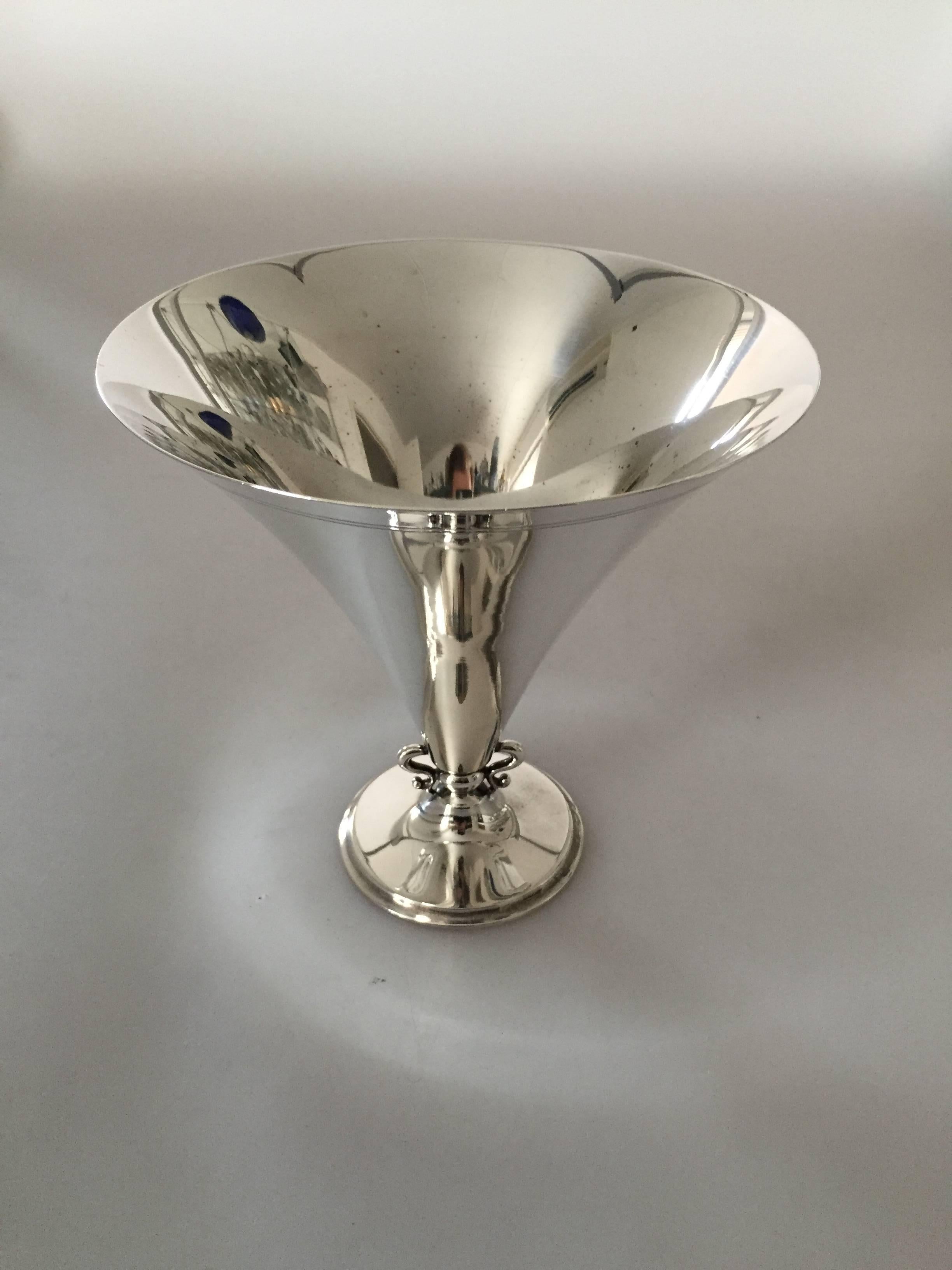 Just Andersen silver vase made at GAB, Sweden.

Just Andersen (1884-1943) was a Danish silversmith born on Greenland. He began his company in 1918 producing both corpus and silverware of high quality. Through his 1st wife he came in touch with the