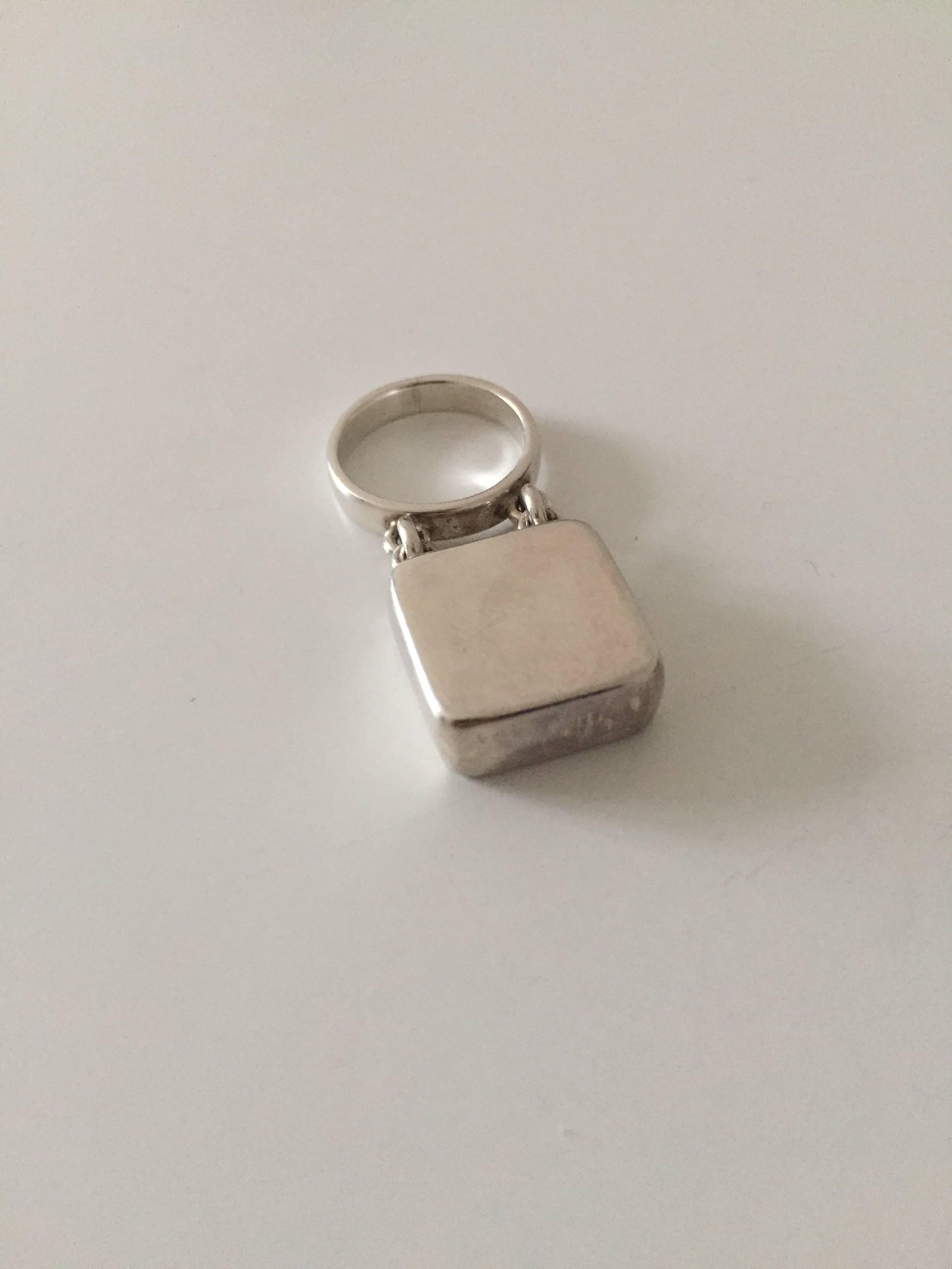 Georg Jensen sterling silver ring by Astrid Fog #143. 

Ring size is 53. 
Weighs 9.6 g / 0.34 oz
Attached silver piece measures 1.5 x 1.5 cm 

Astrid Fog (1911-1993) Danish designer and jewelry artist. 

Georg Jensen (1866-1935) opened his