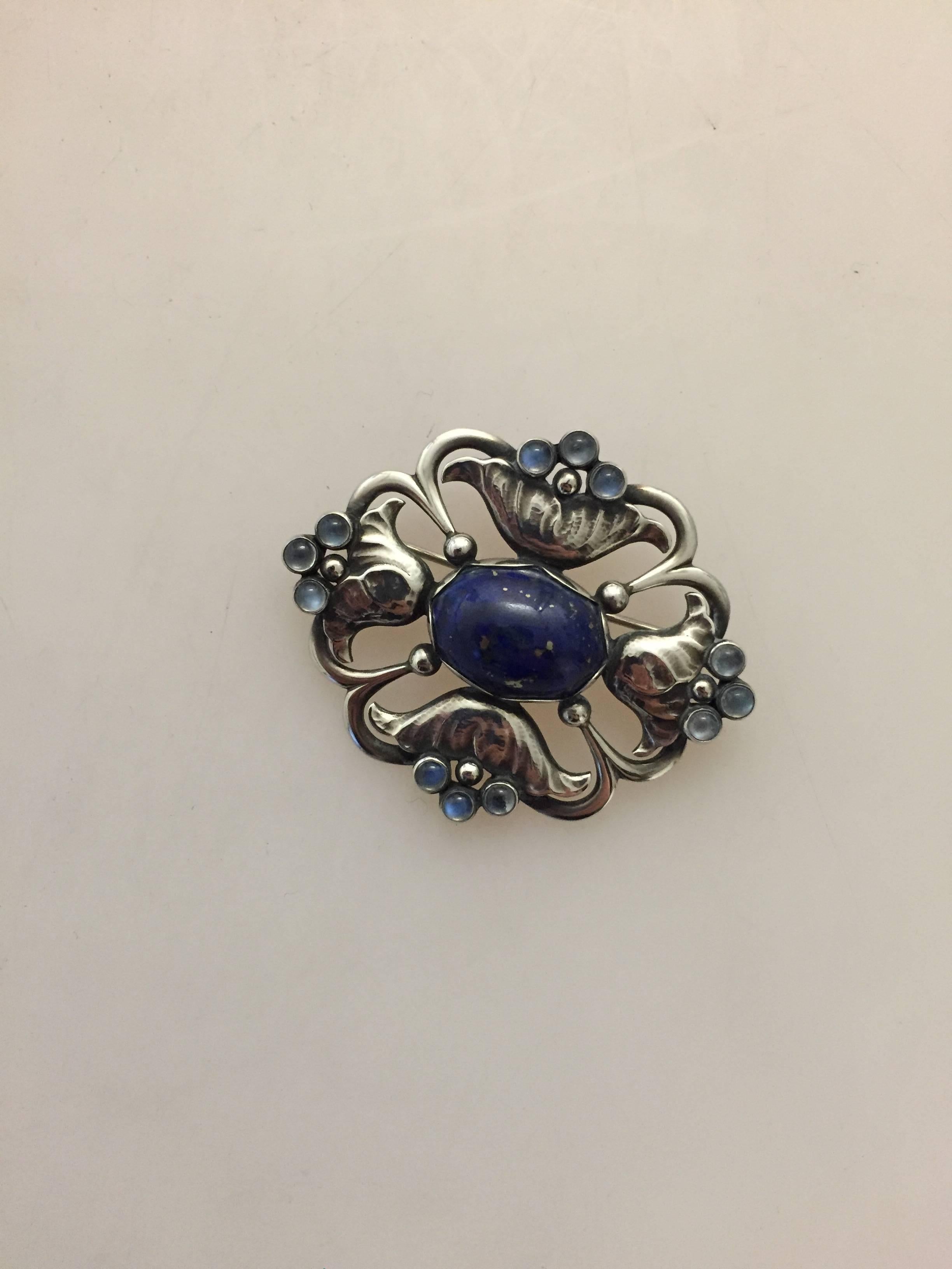 Georg Jensen Sterling Silver Brooch with Lapis Lazuli and Moonstones #173. From after 1945.

 Measures 5.3 cm x 4.3 cm (2 3/32