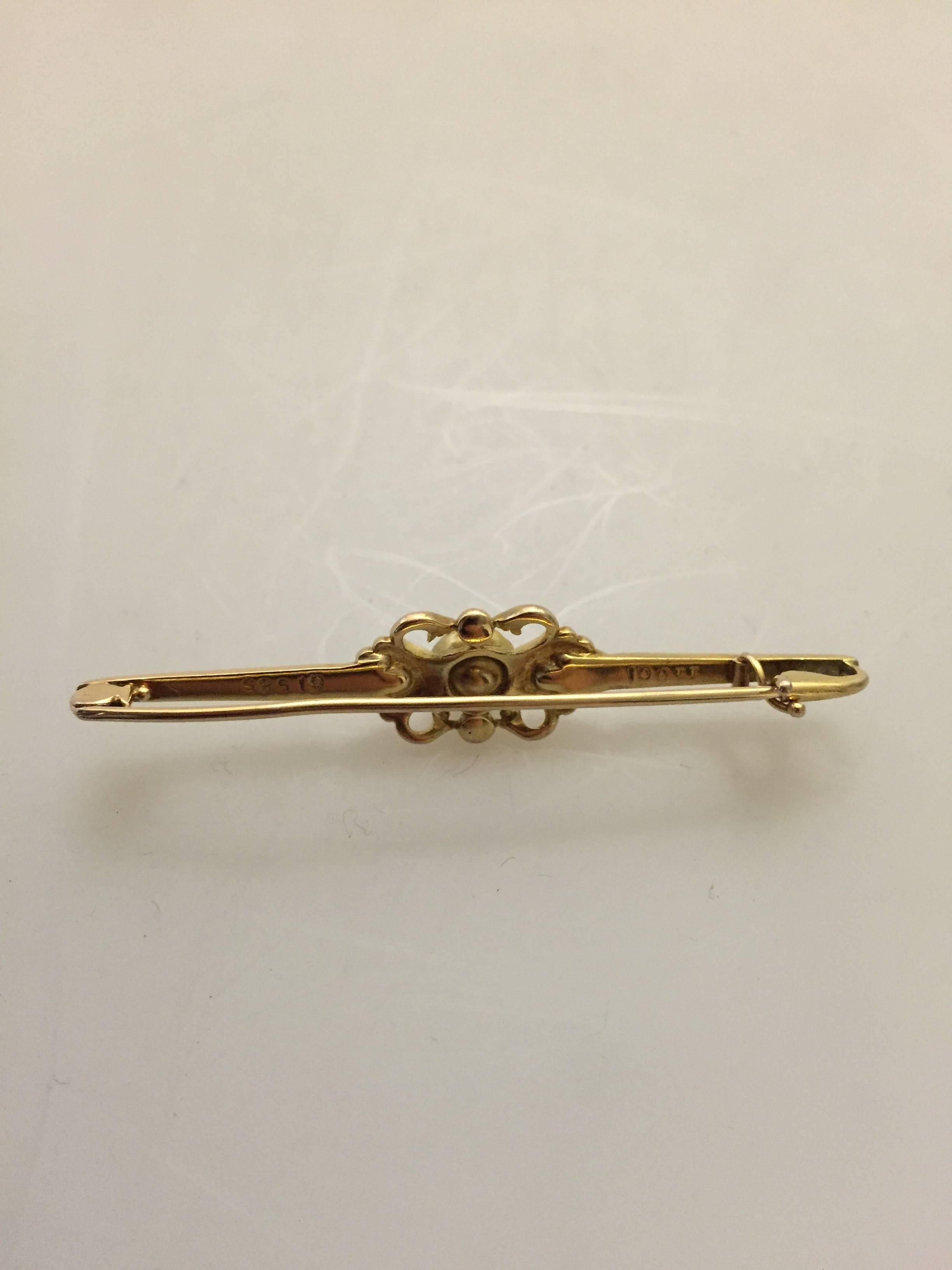 Georg Jensen 14-karat gold brooch with pearl #110.

 Measures 5.5 cm L (2 11/64