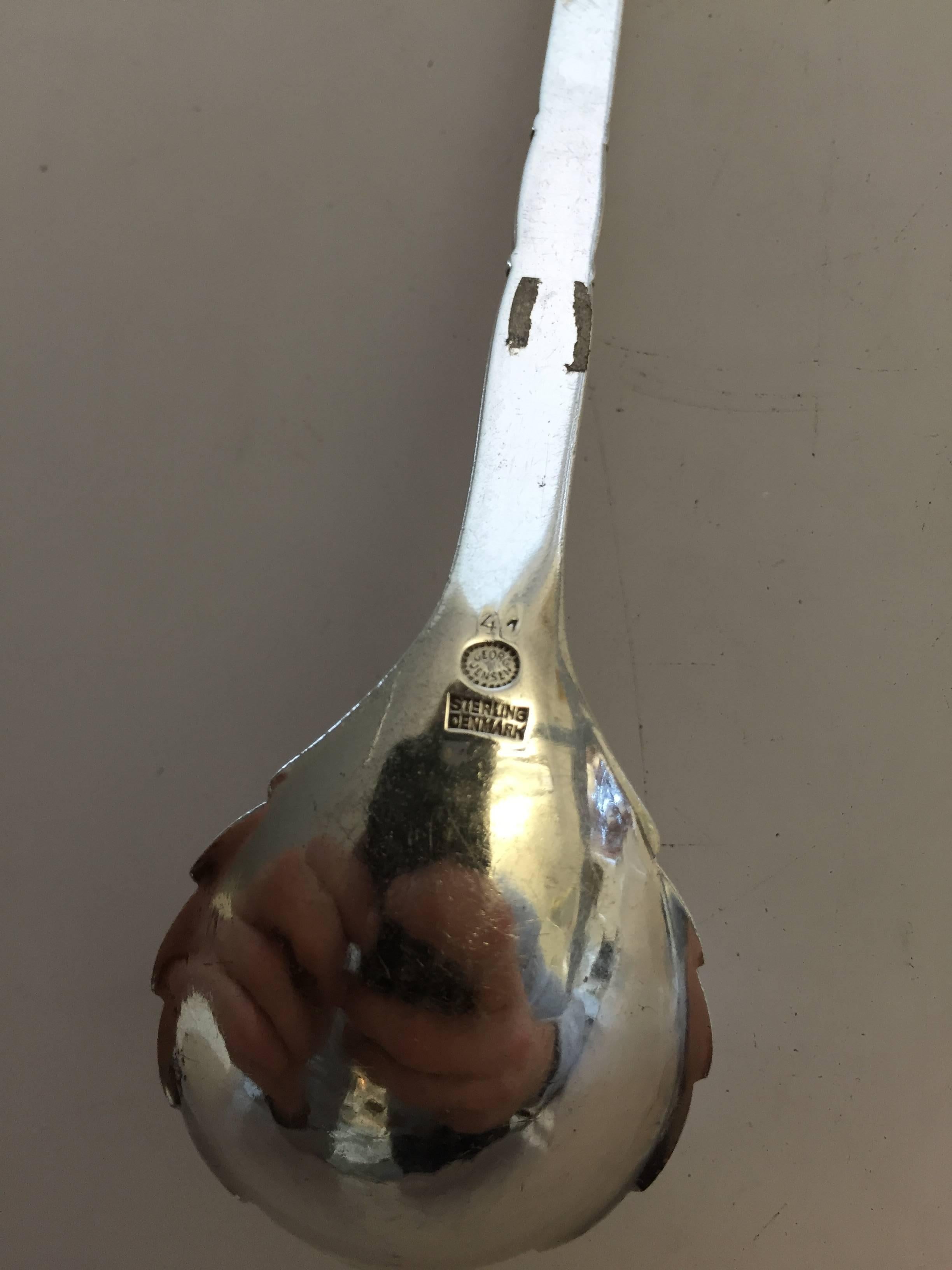 Georg Jensen sterling silver ornamental serving spoon #41. 

Measures 13.5 cm.
Weighs 1.15 oz / 34 g.
 