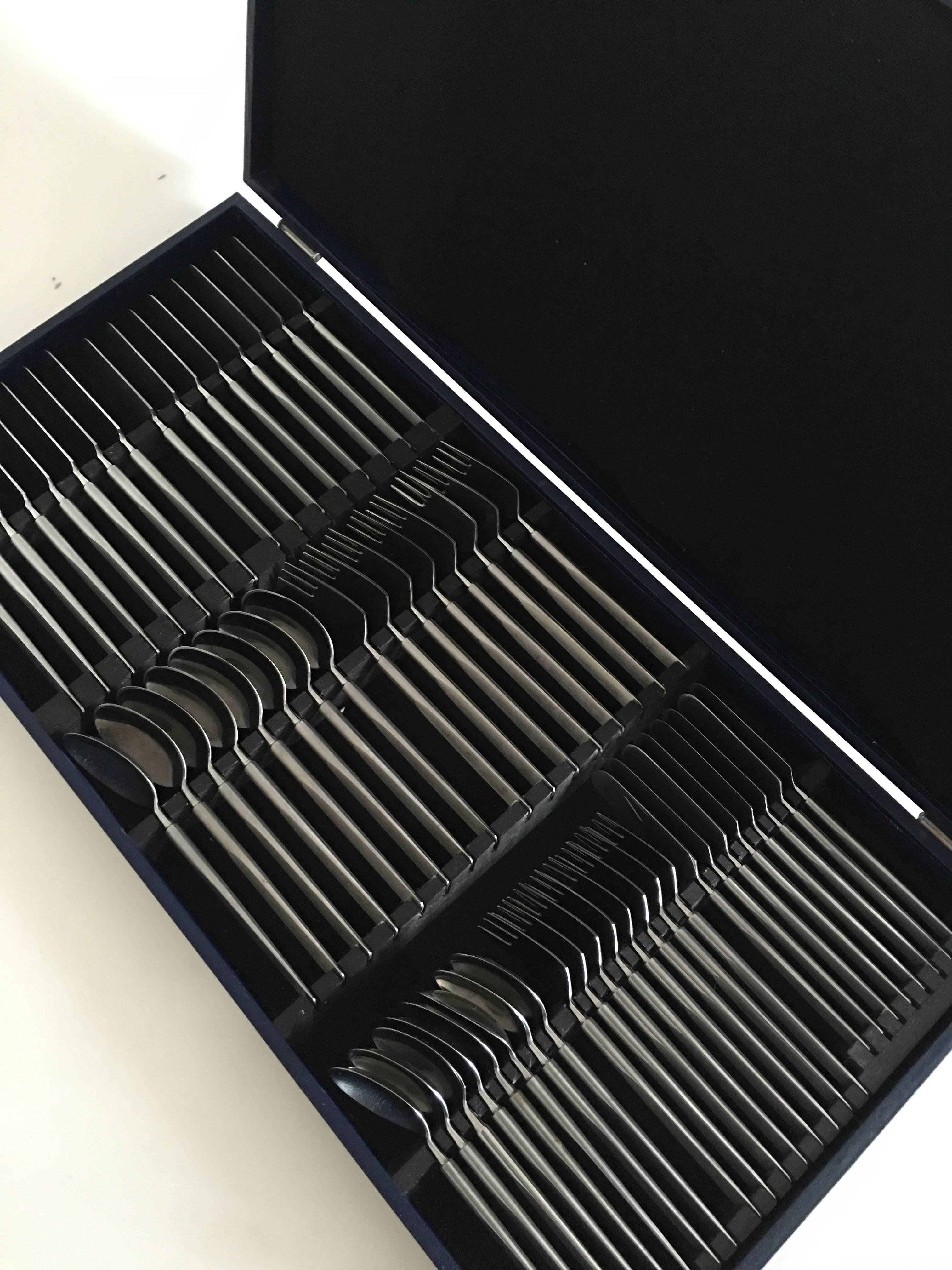 Erik Herlöw stainless steel flatware obelisk set of 56 pieces. 

Eight dinner knives.
Eight luncheon knives.
Eight dinner spoons.
Eight dinner forks.
Eight dessert spoons.
Eight luncheon forks.
Eight butter knives.

The set comes with the