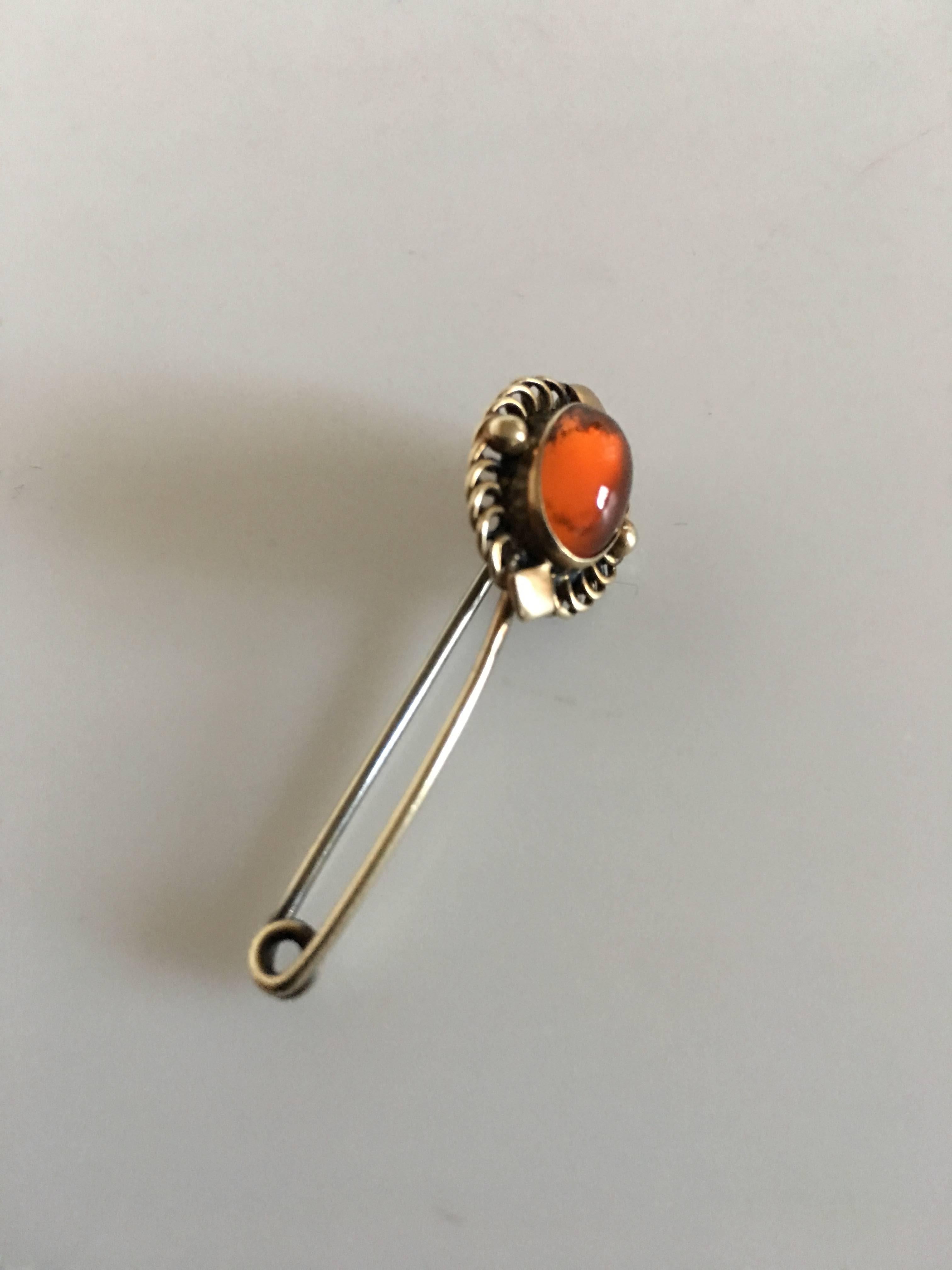 Georg Jensen gilded silver brooch #2 with amber. Made of 830 silver. From 1915-1925. In nice condition. Measures 3.8 cm L (1 1/2