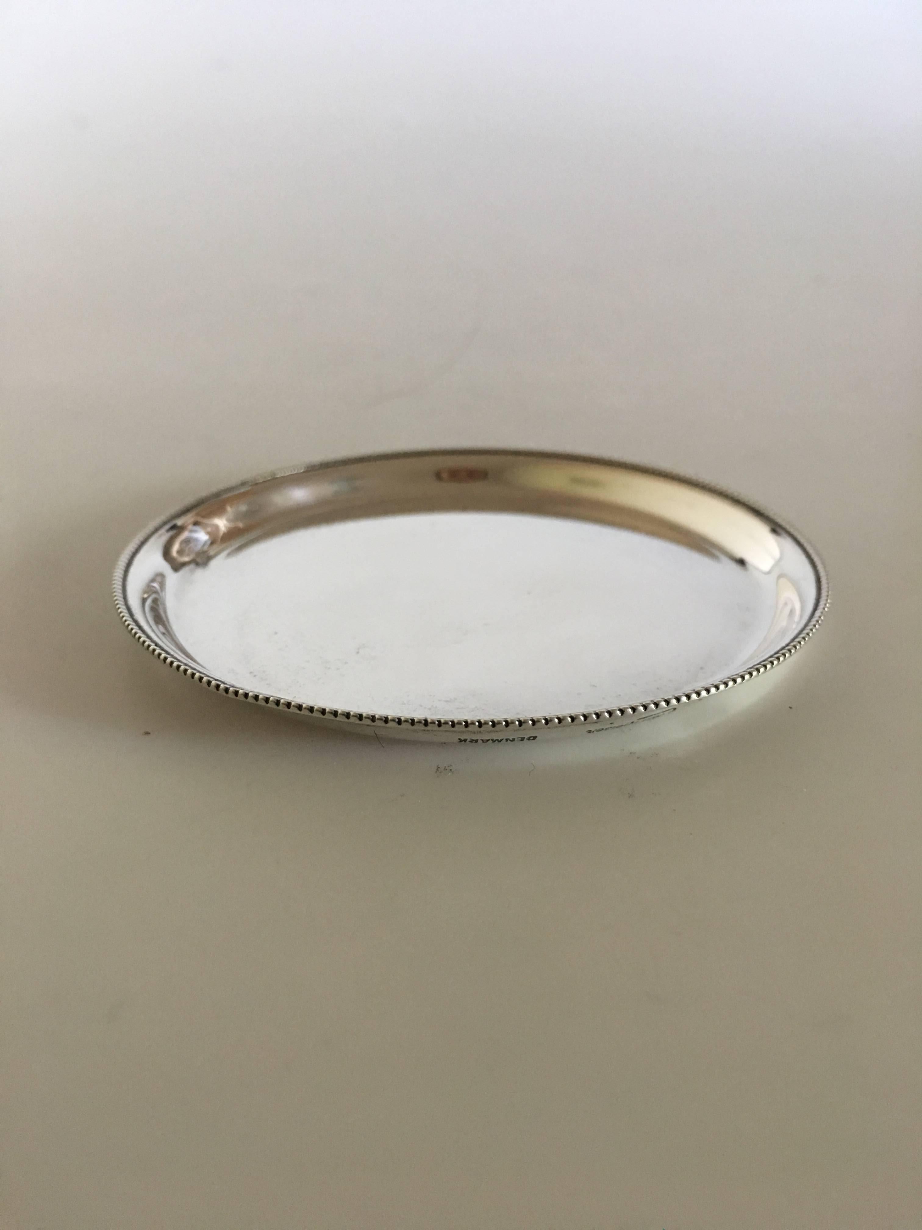 Evald Nielsen sterling silver glass coaster. Fits a glass with maximum 6.5 cm diameter footing. Weighs 30 grams.