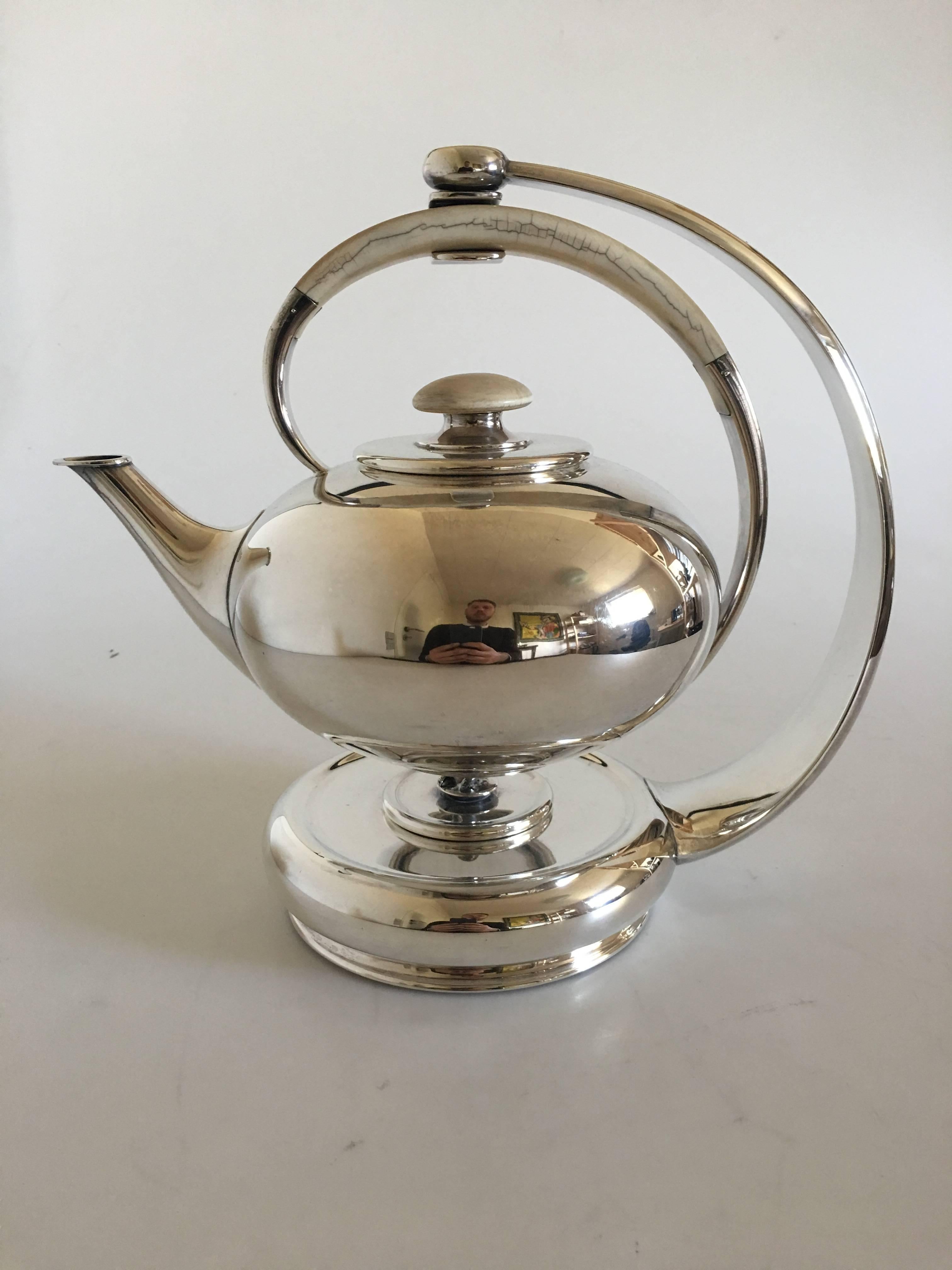F. Hingelberg sterling silver teapot with bone handle and matching heating stand. The tea pot measures to the top of the handle 18 cm H (7 3/32