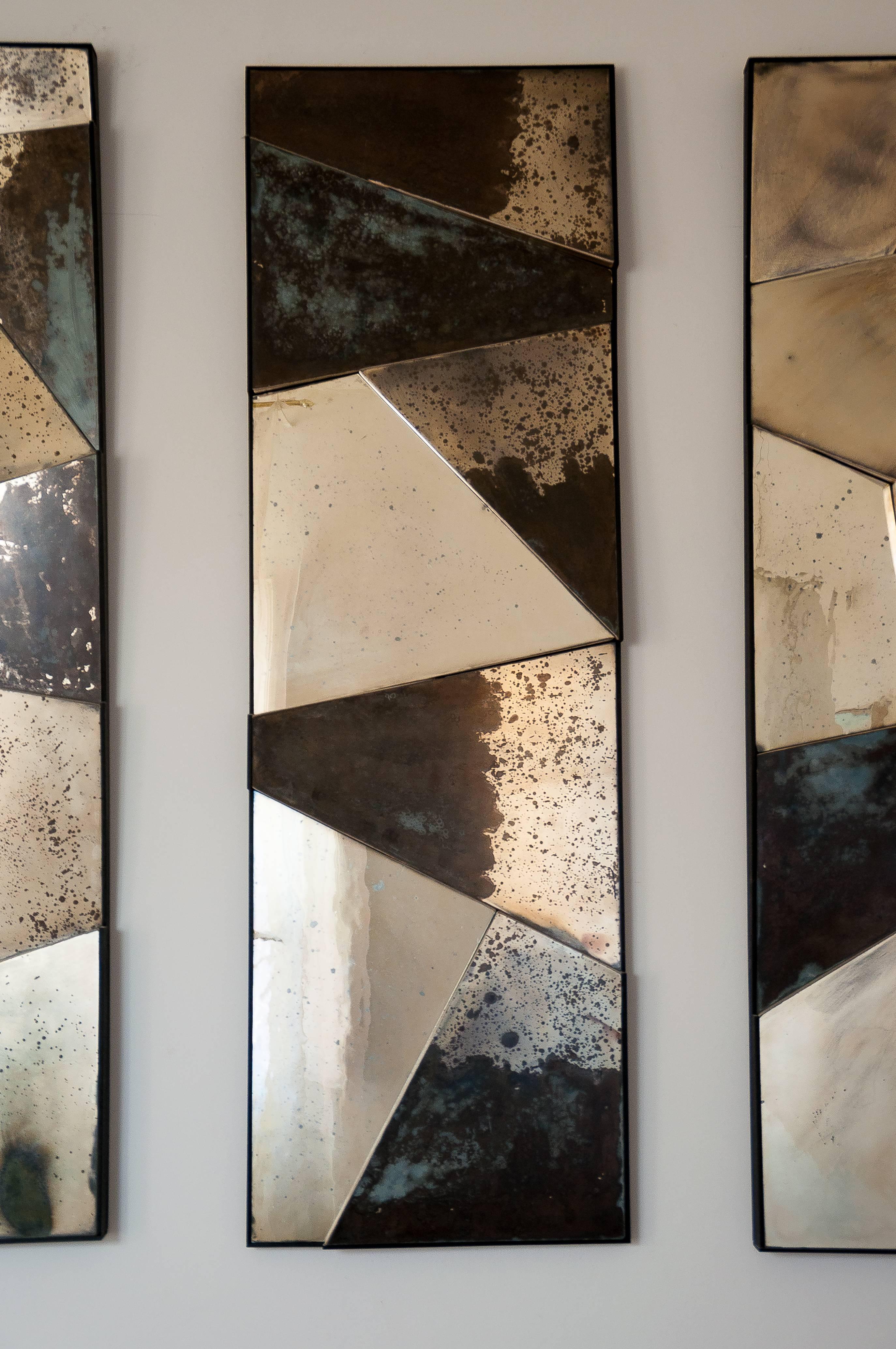 Three-dimensional mirror sculpture in contemporary silver glass.
The pieces radiate reflections and interact with the surrounding environment with elegance and character. The edges, made of dark vengé wood, are irregularly cut following the glass