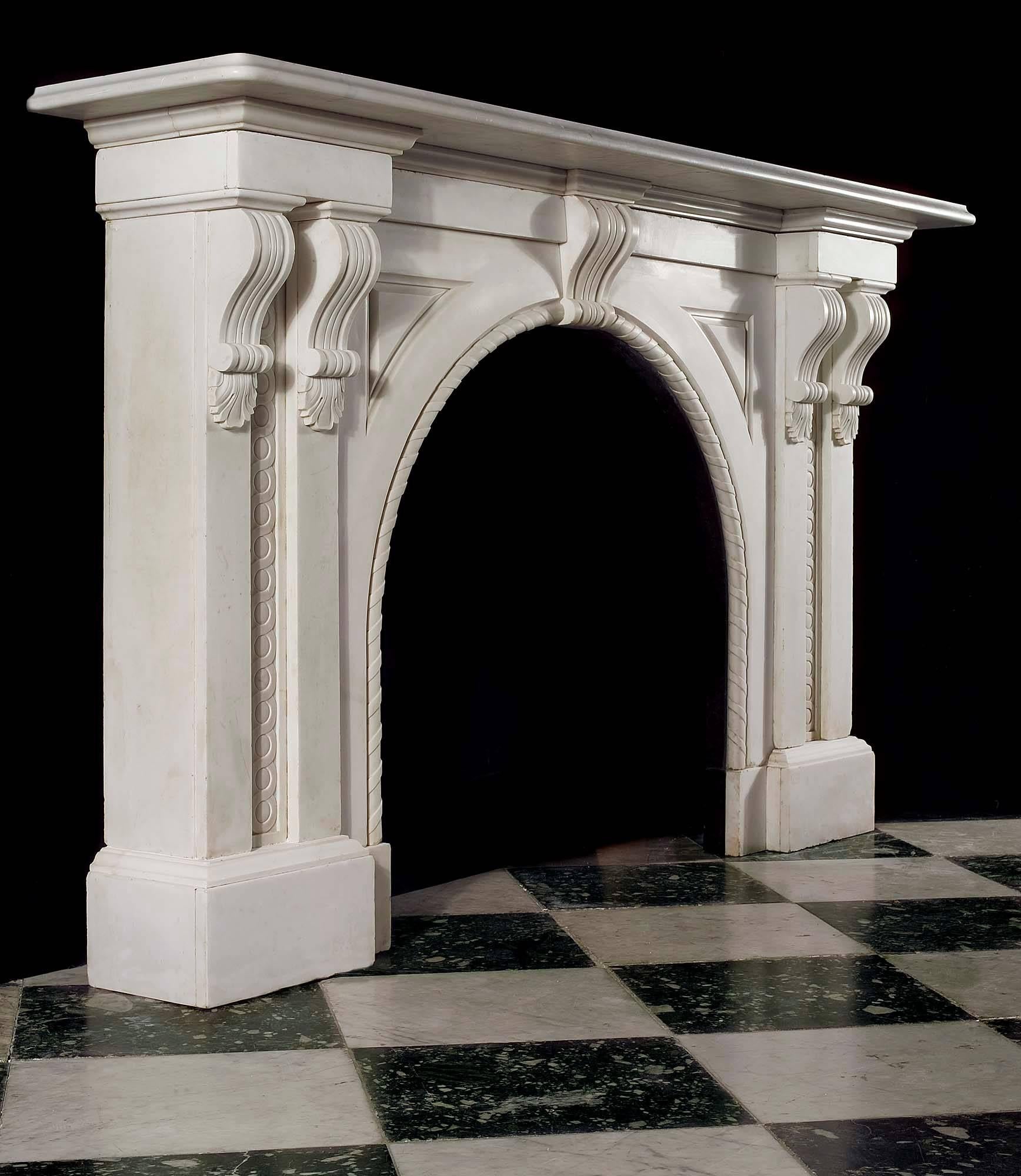 A large and imposing Victorian arched fireplace carved in Italian white marble. The massive plain moulded shelf is supported on twin scrolled brackets descending into twin pilasters each side with carved guilloche motif inset in the panels, either
