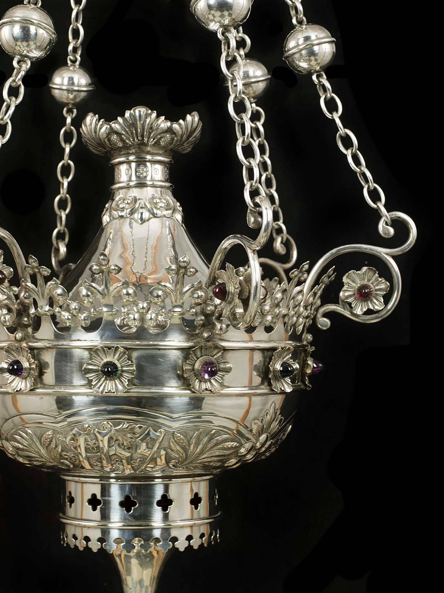 A magnificent and rare Gothic Revival, Byzantine influenced antique silver plated incense burner. The highly decorative bowl, set with many coloured glass cabochon and bearing the initials I H S a symbolic monogram of Christ, is suspended from a