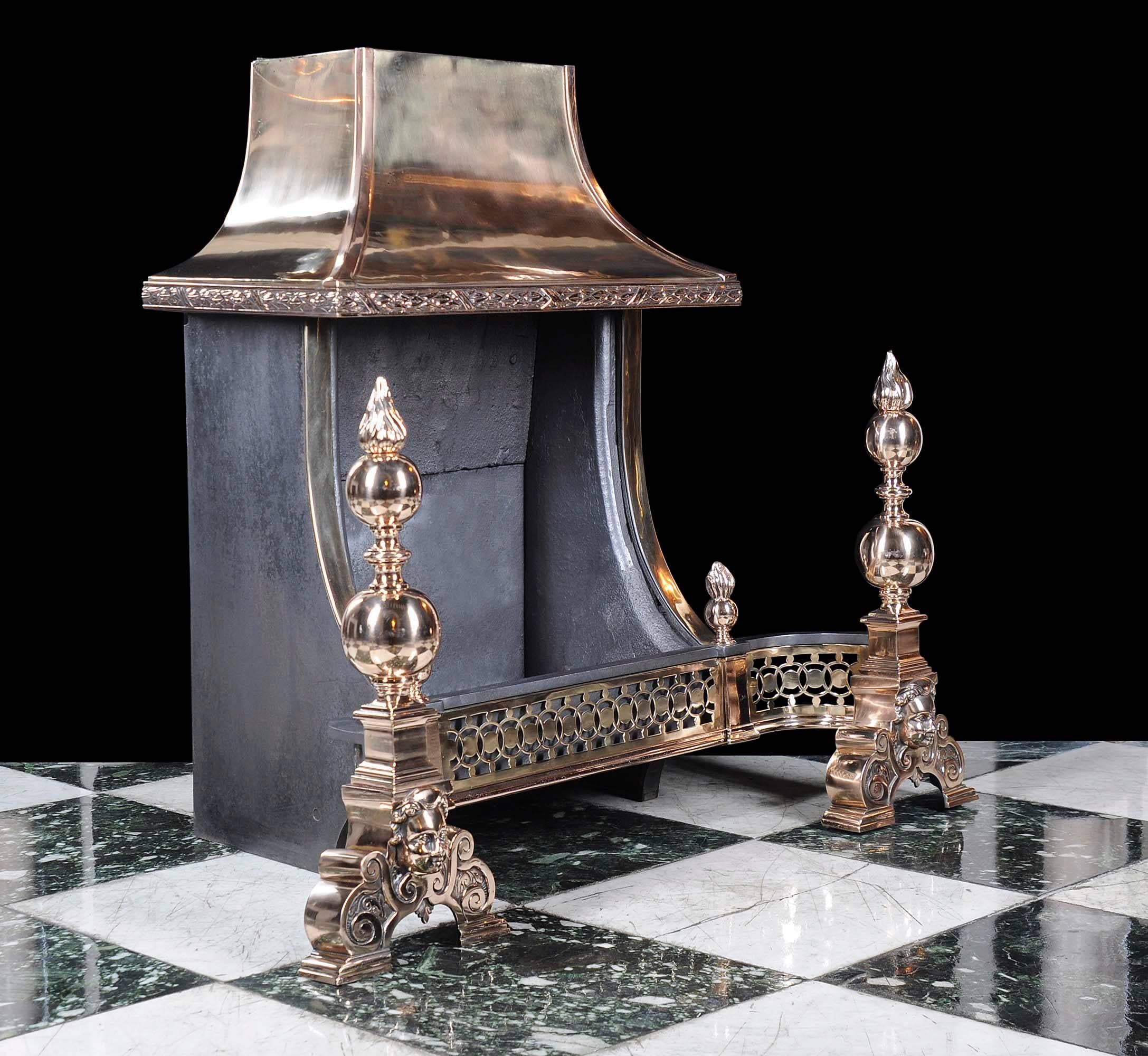 A large bronze hooded Victorian fire grate with pierced curved apron mounted with a pair of small flambeau finials supported on substantial baluster firedogs in the Baroque manner. 

English late 19th century.
  