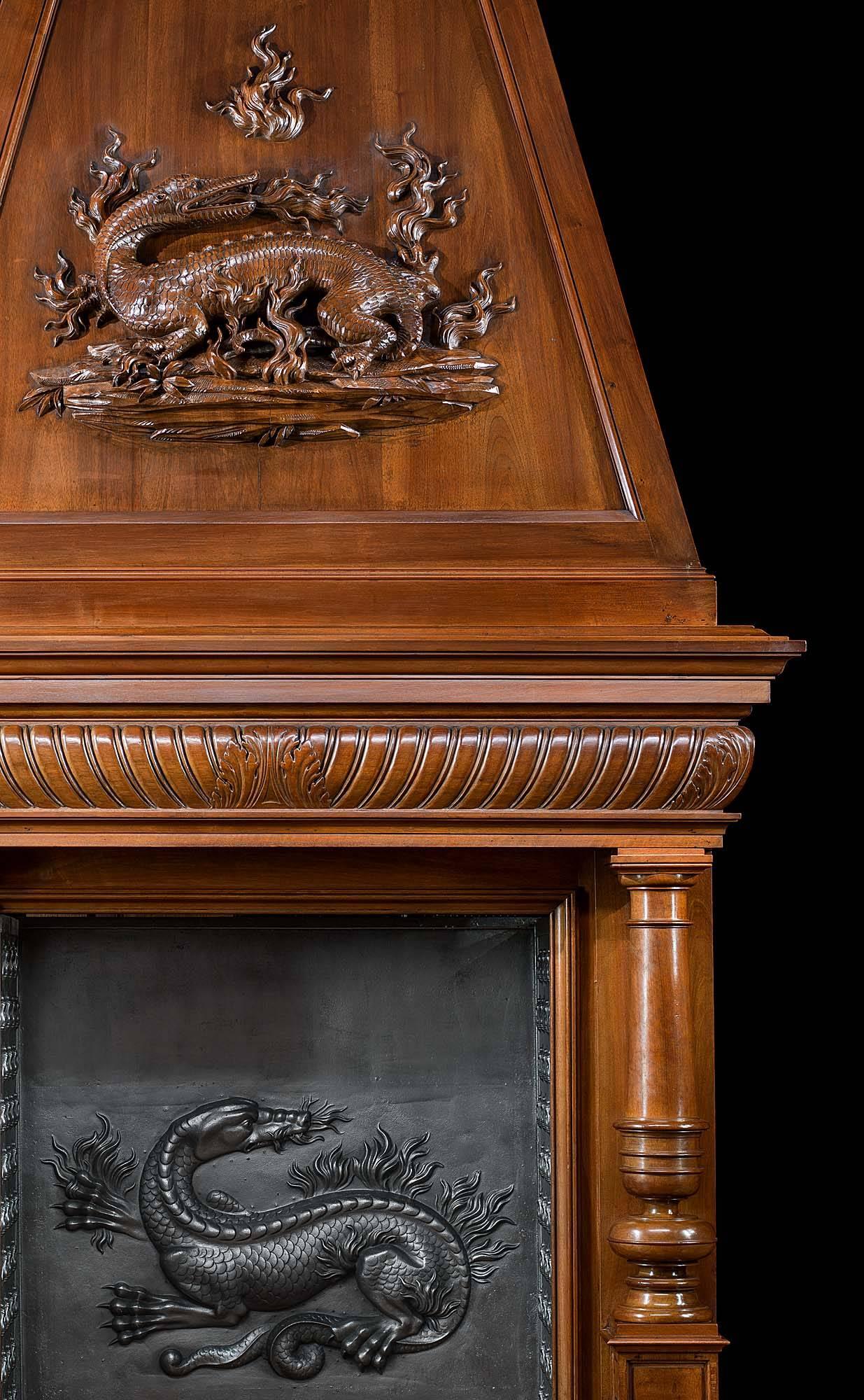 A very tall and imposing antique walnut trumeau chimneypiece deeply carved with a salamander surrounded by flames in high relief on the trumeau. The fireplace surround, with a rectangular opening and a wide gadrooned frieze centred by acanthus