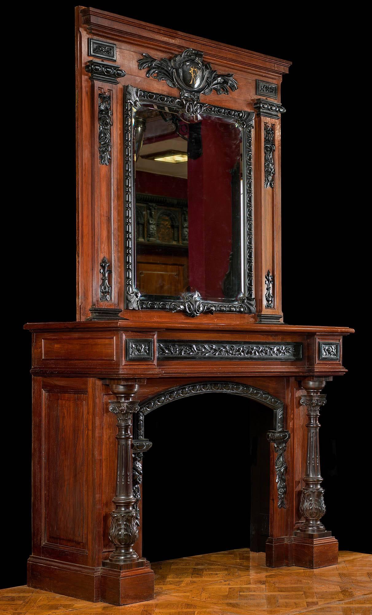 A tall and stately French Baroque style rosewood and ebony chimneypiece. The mirror, framed with egg and dart and fleur-de-lys decoration, is set beneath a large cartouche centred with a monogrammed boss with the letters FF and is flanked by ebony