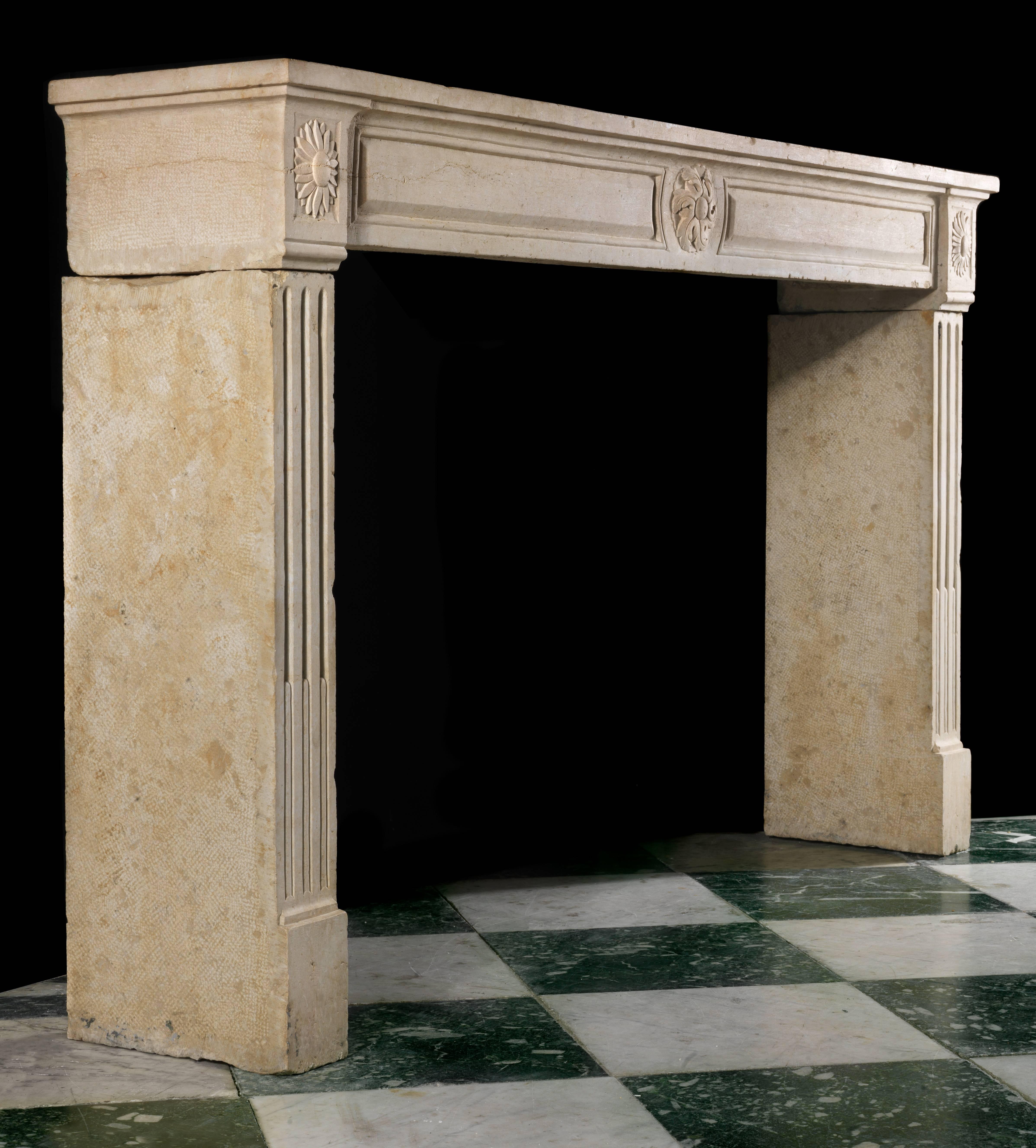 A wide limestone Louis XVI chimneypiece with a carved fielded frieze centred by a stylized rosette echoed on the end blocks above step fluted jambs,

French, 18th century. 

(Price and vat in EU zone).
 